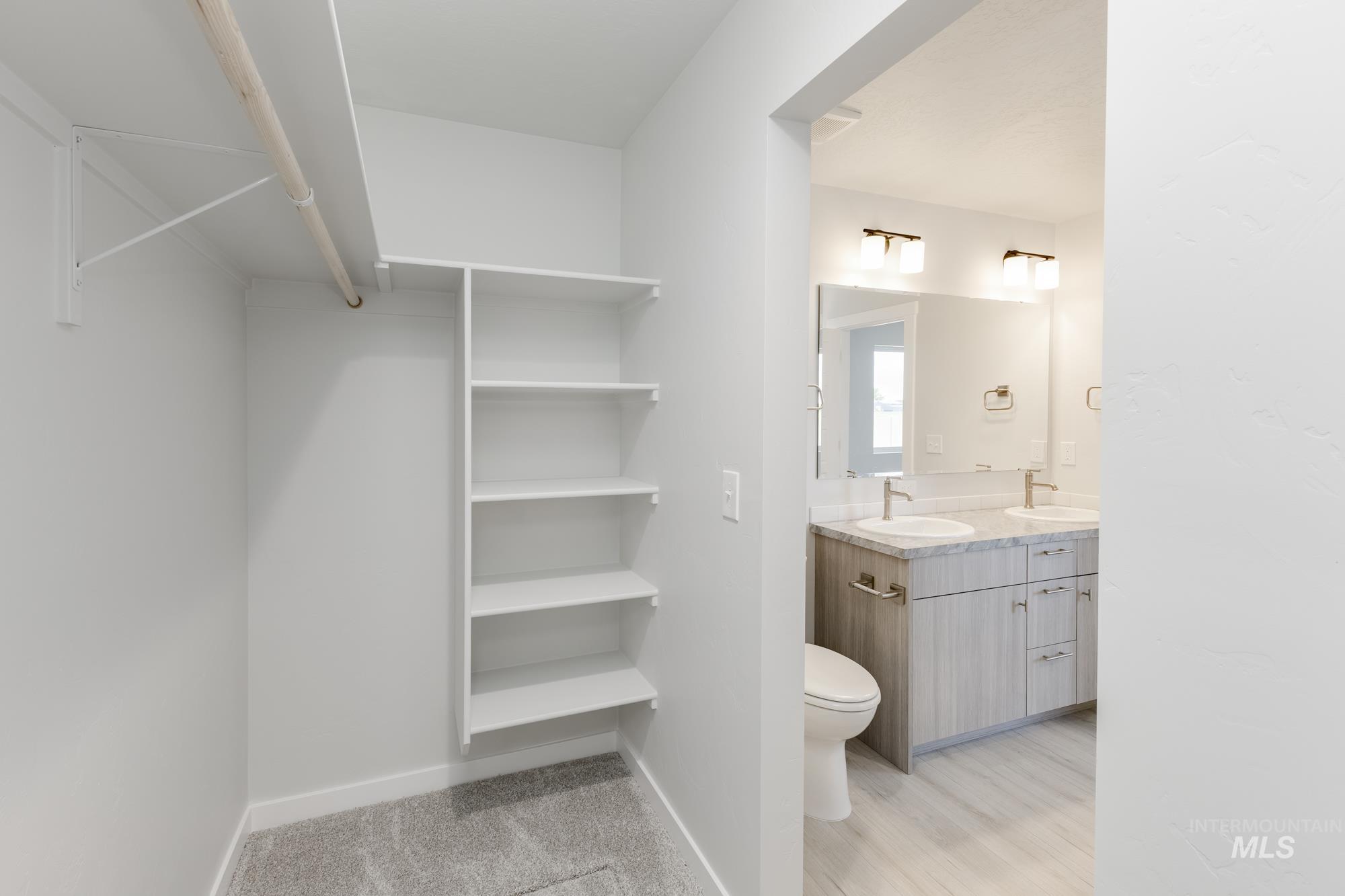 Full bath featuring double vanity and wood finished floors