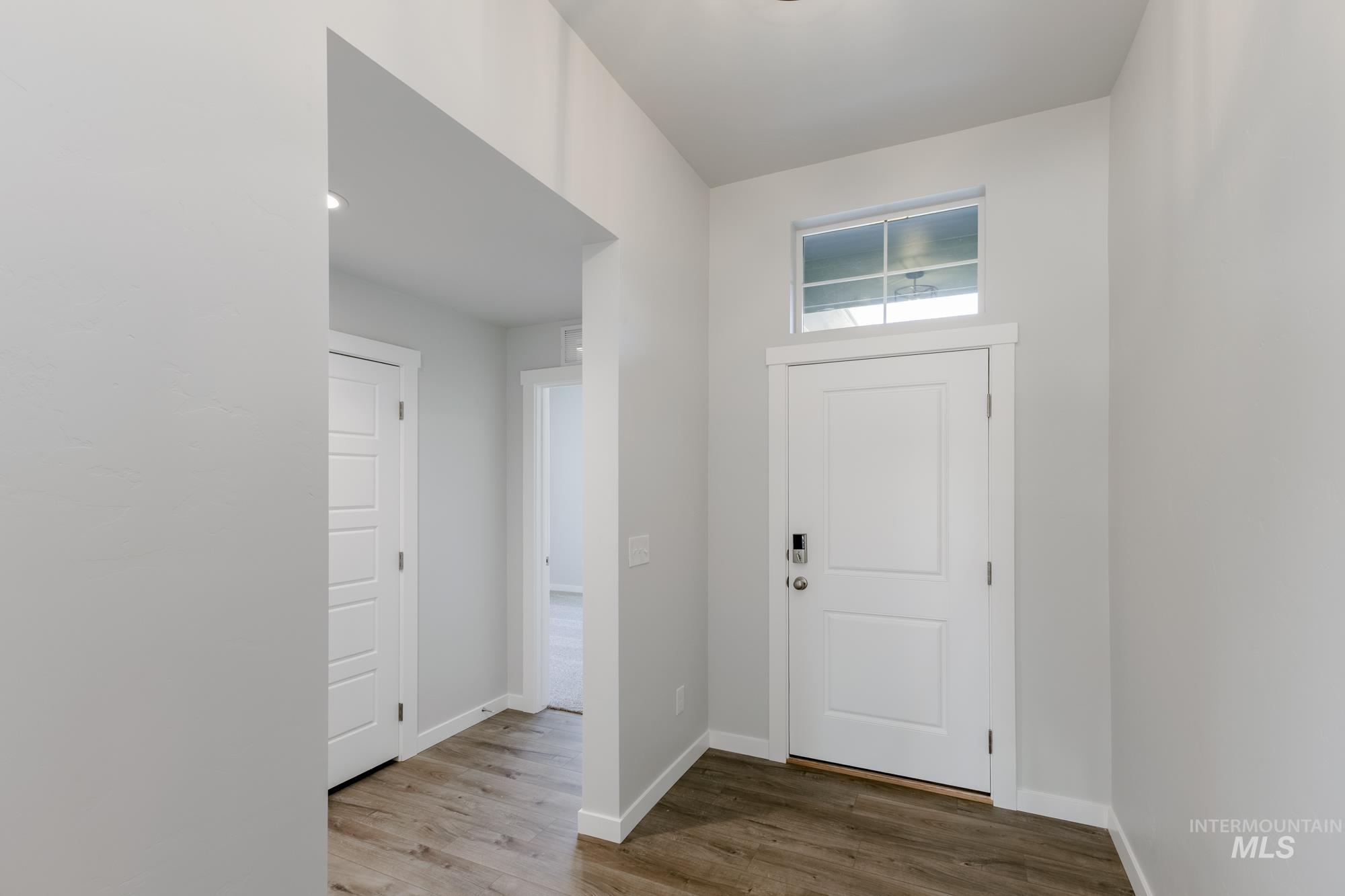 Entryway featuring baseboards and wood finished floors