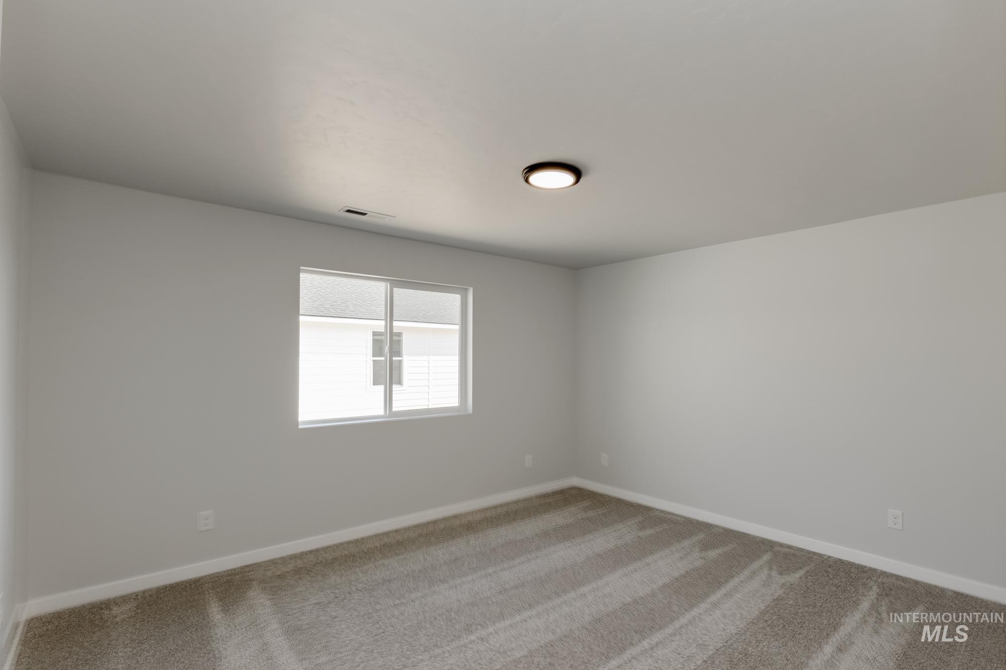 Empty room featuring carpet and baseboards