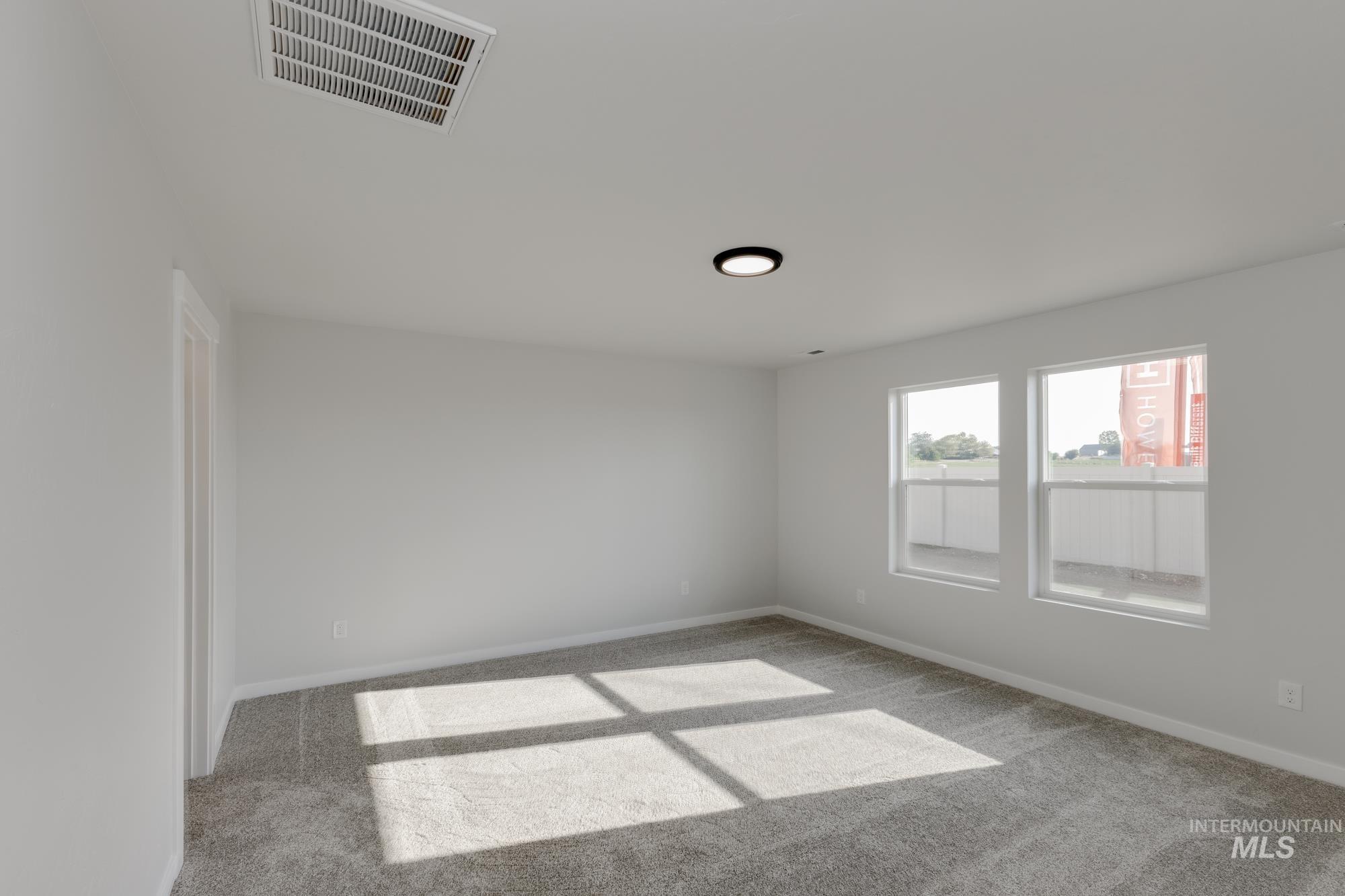 Spare room with carpet and baseboards