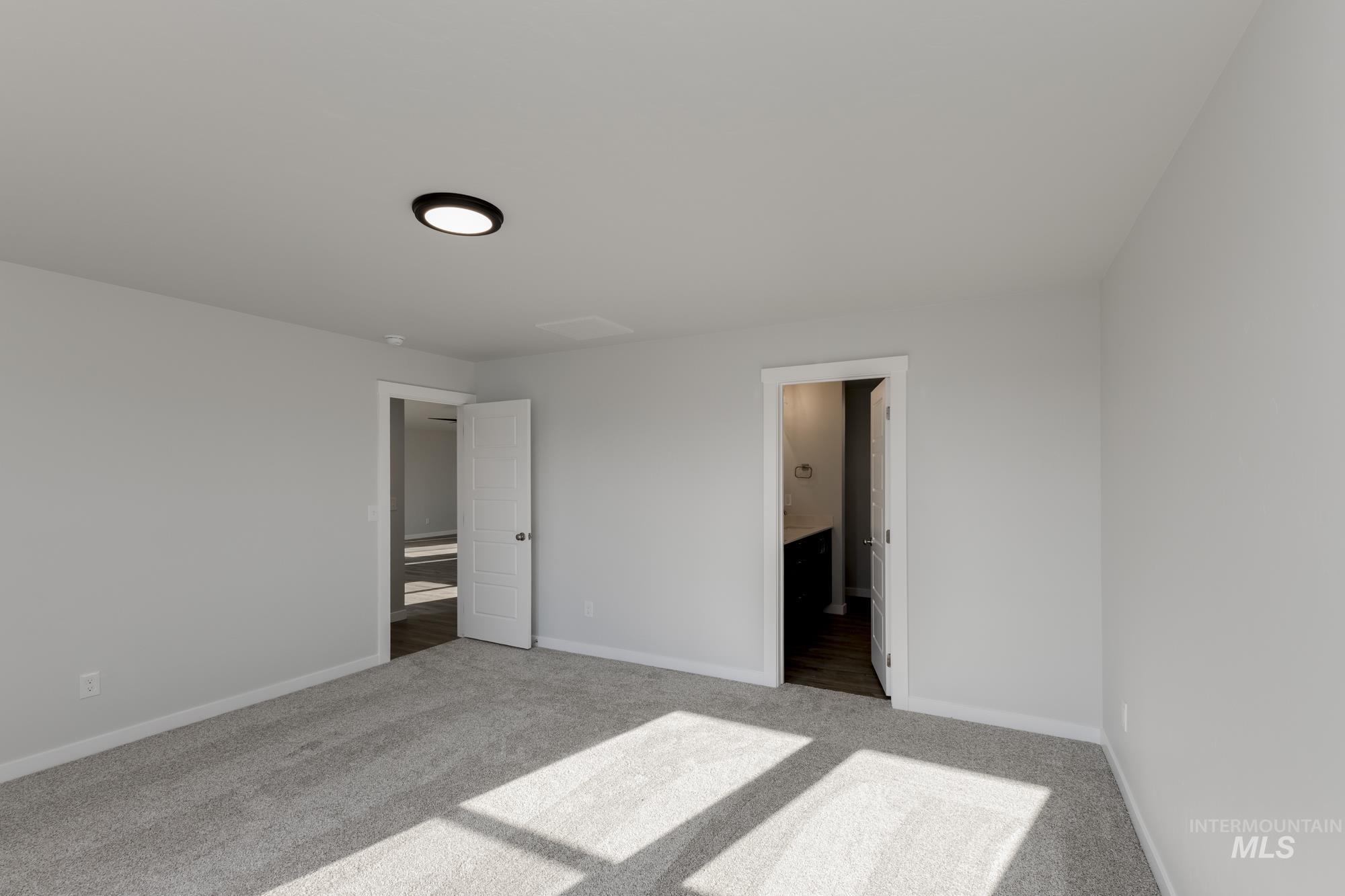 Unfurnished bedroom featuring carpet flooring and ensuite bathroom