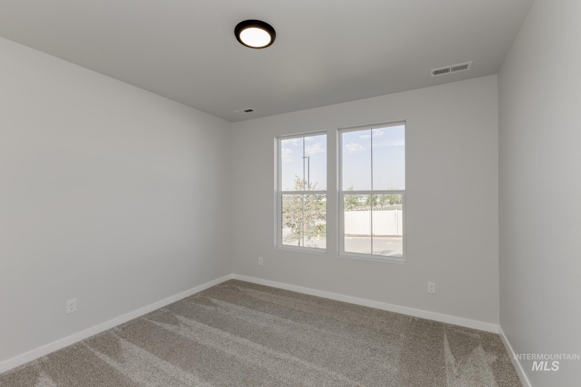 Carpeted spare room with baseboards