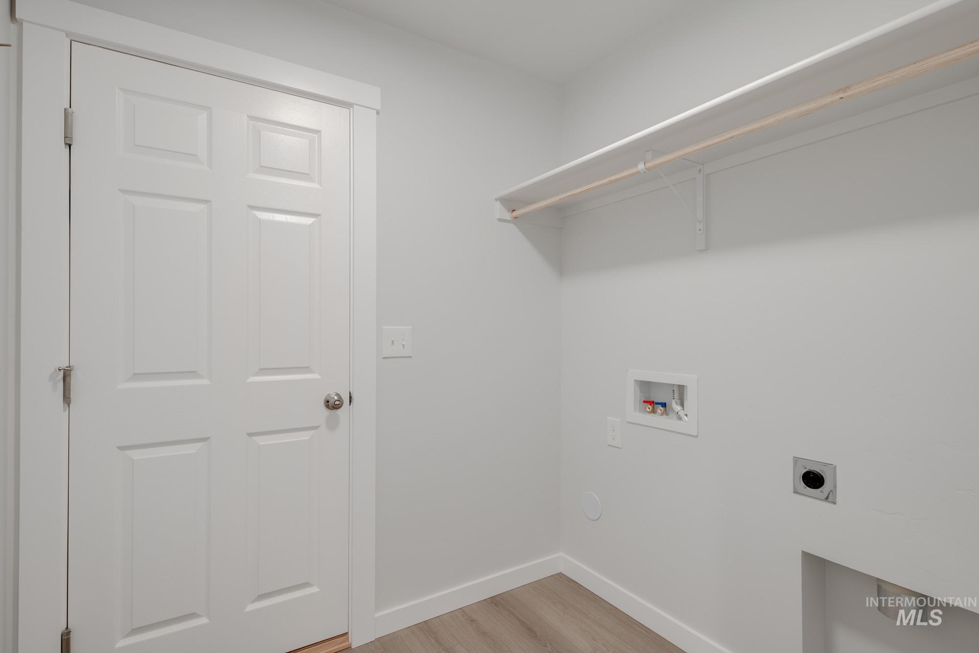 Laundry area featuring hookup for an electric dryer, washer hookup, and light wood finished floors
