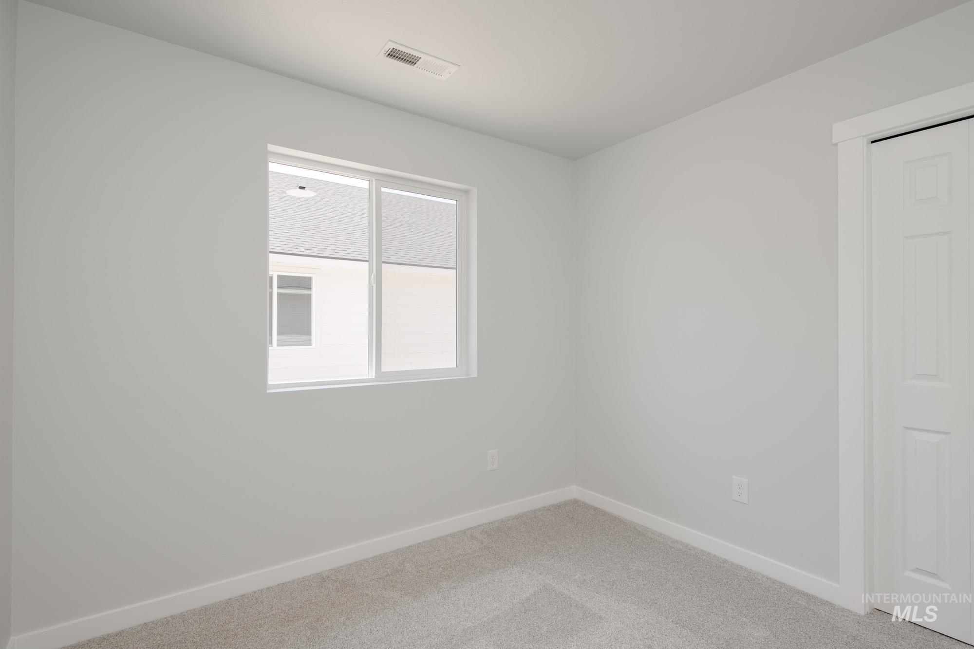 Unfurnished room with baseboards and light colored carpet