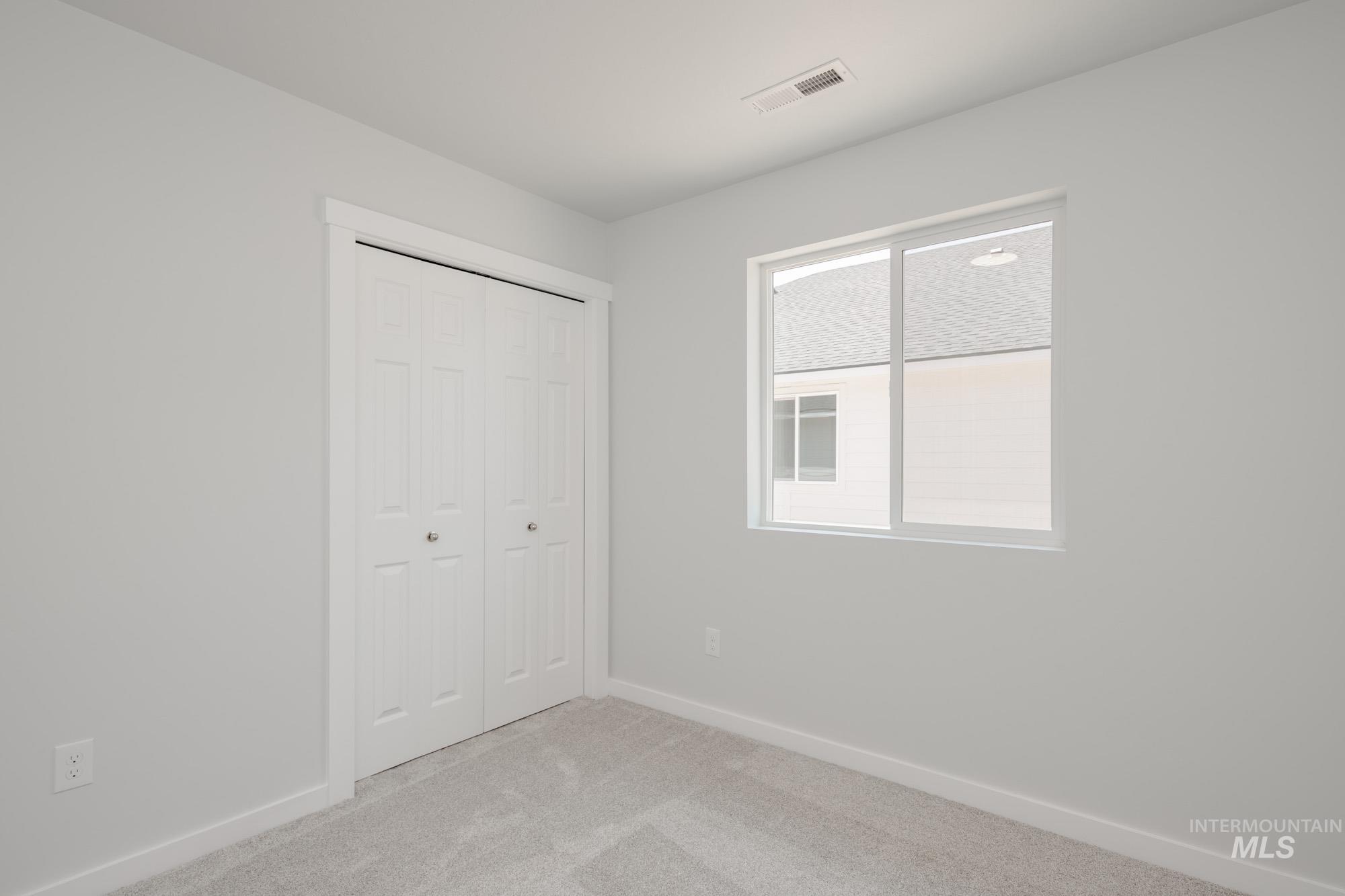 Unfurnished bedroom featuring light colored carpet and a closet
