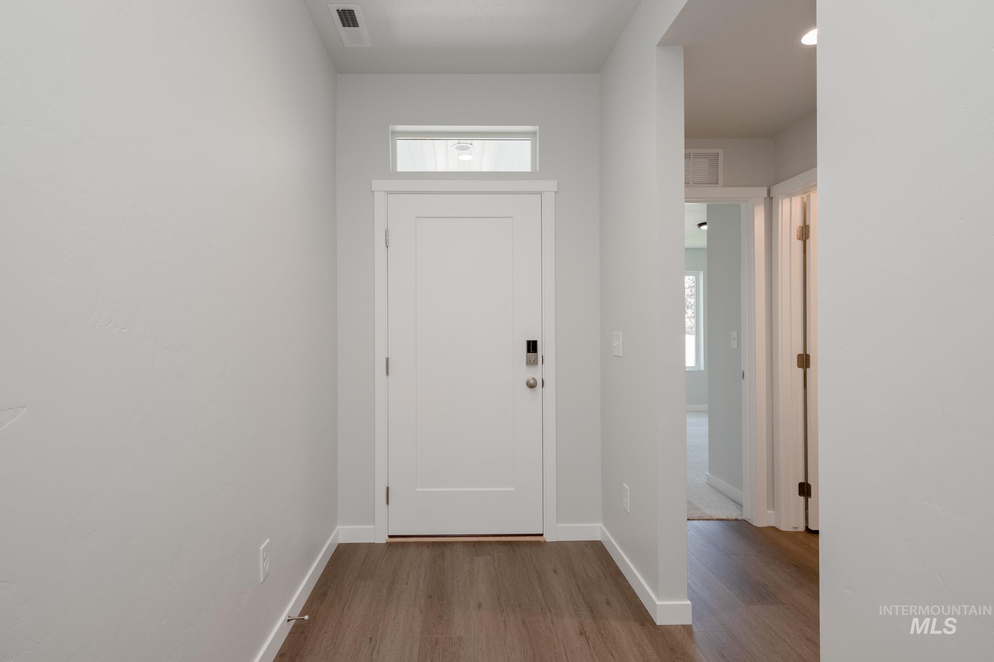 Foyer entrance with wood finished floors and baseboards