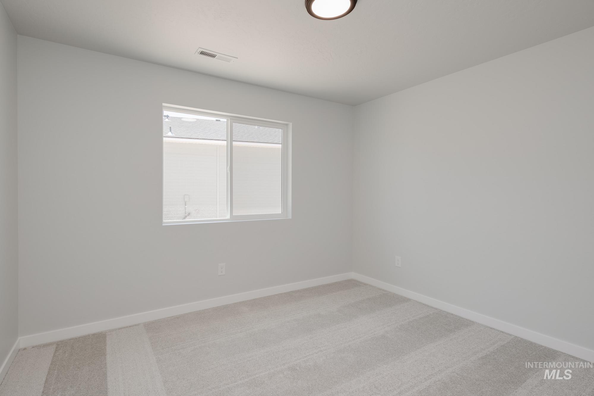 Carpeted empty room with baseboards