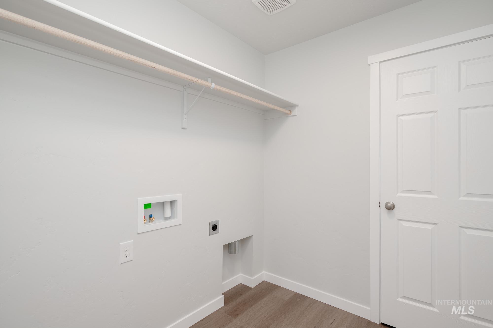 Laundry area featuring hookup for a washing machine, hookup for an electric dryer, and wood finished floors