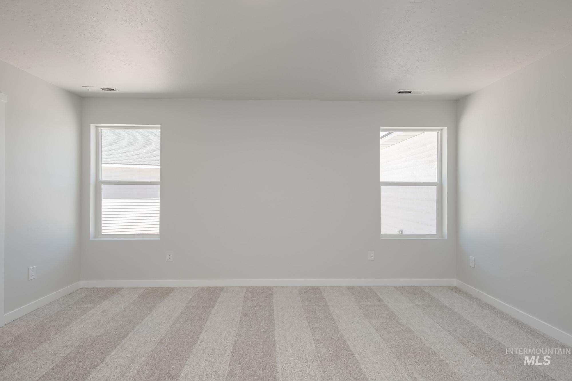 Unfurnished room featuring light colored carpet and baseboards