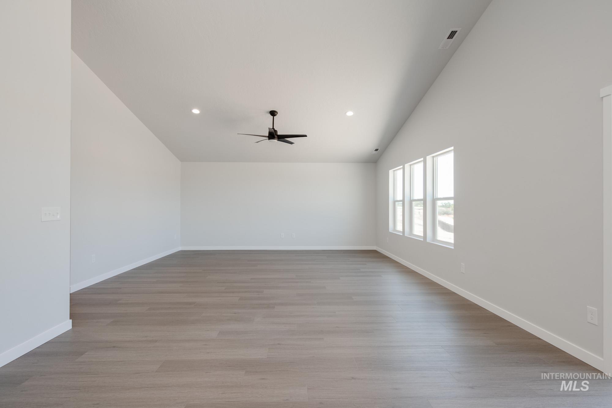 Spare room with ceiling fan, light wood-style flooring, recessed lighting, and high vaulted ceiling