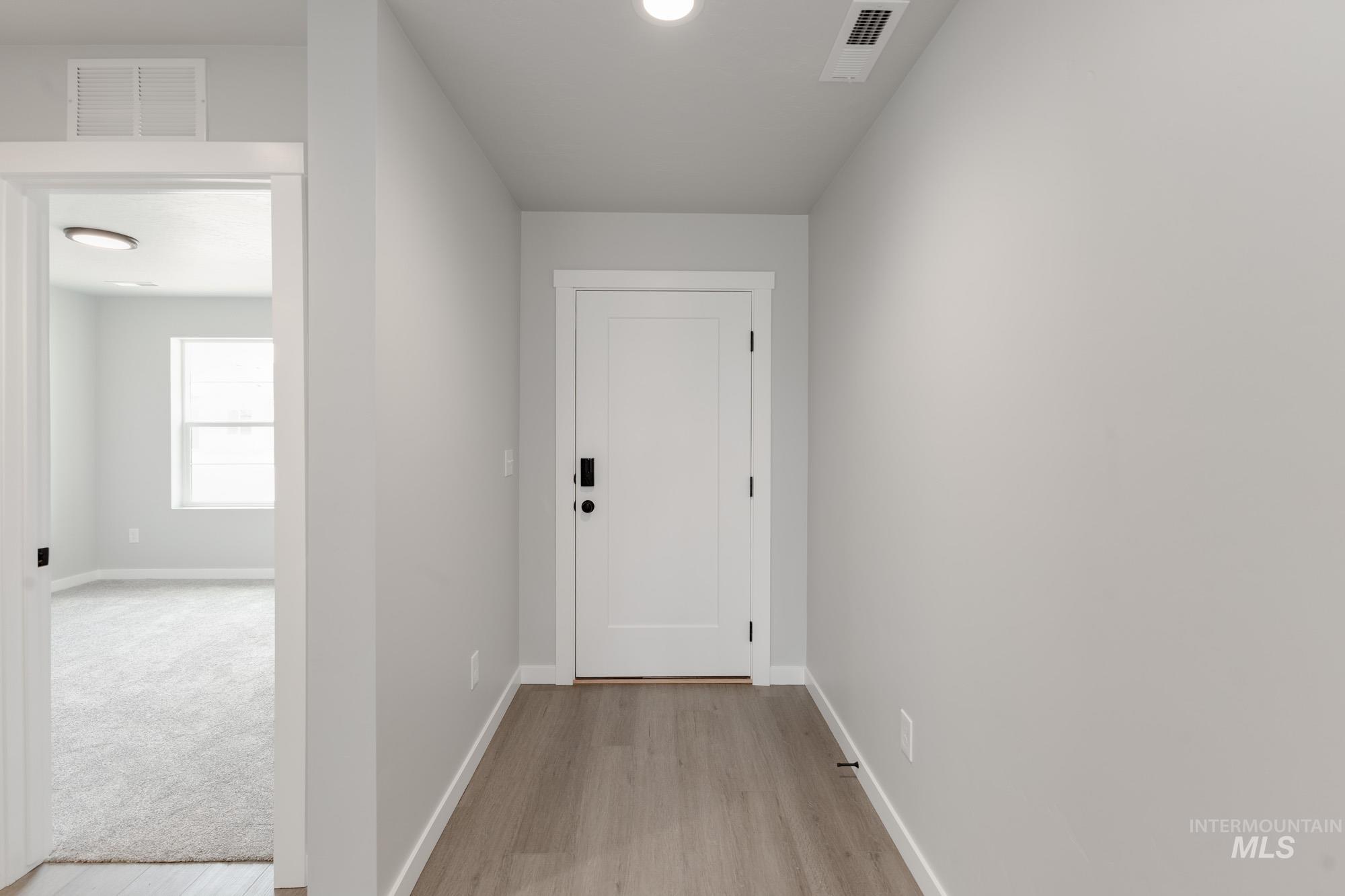 Corridor with baseboards and light wood-style flooring
