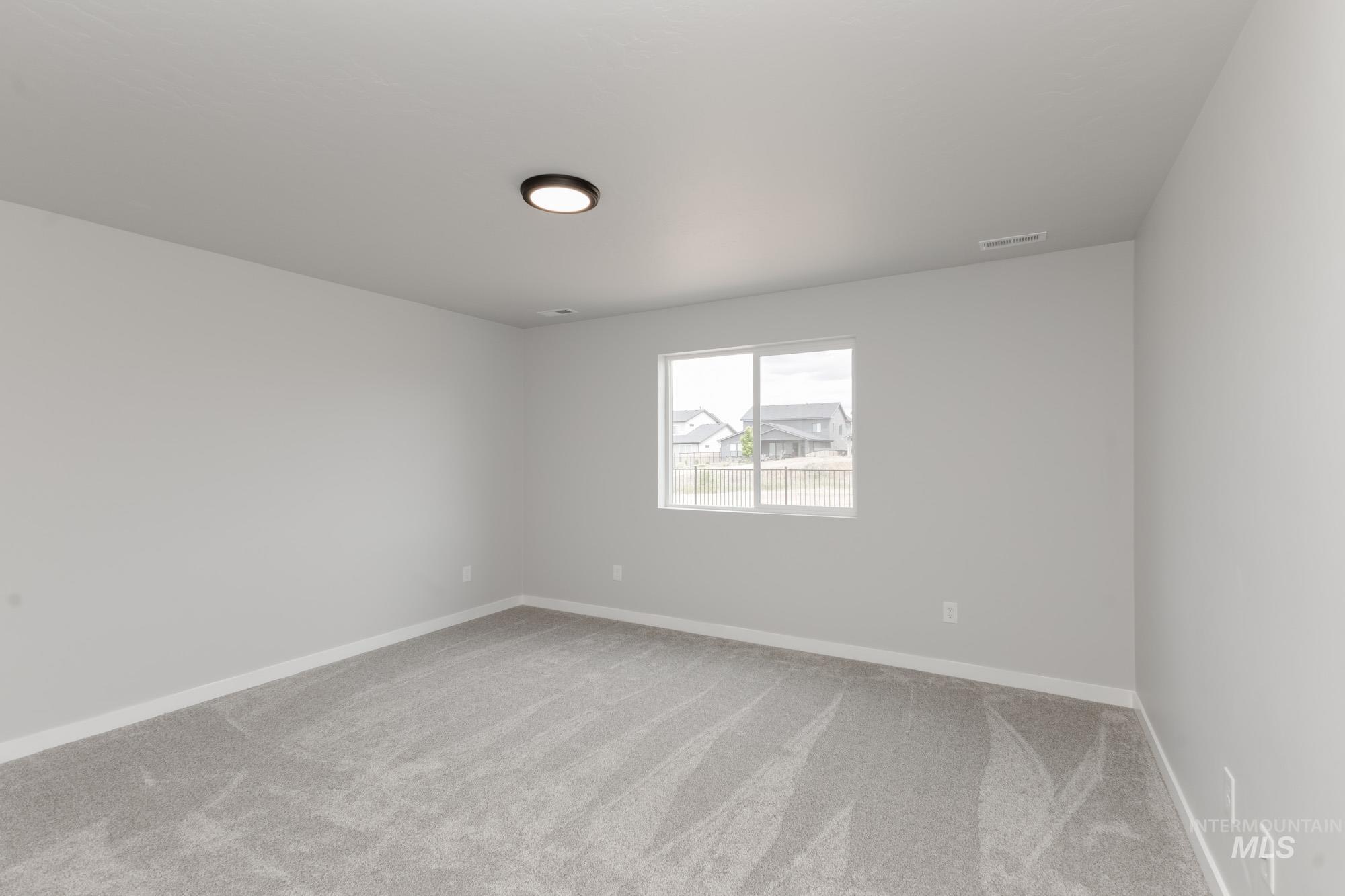 Spare room featuring carpet and baseboards