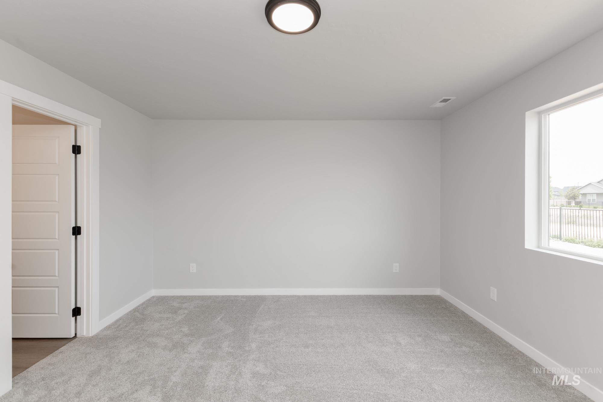 Empty room featuring carpet floors and baseboards