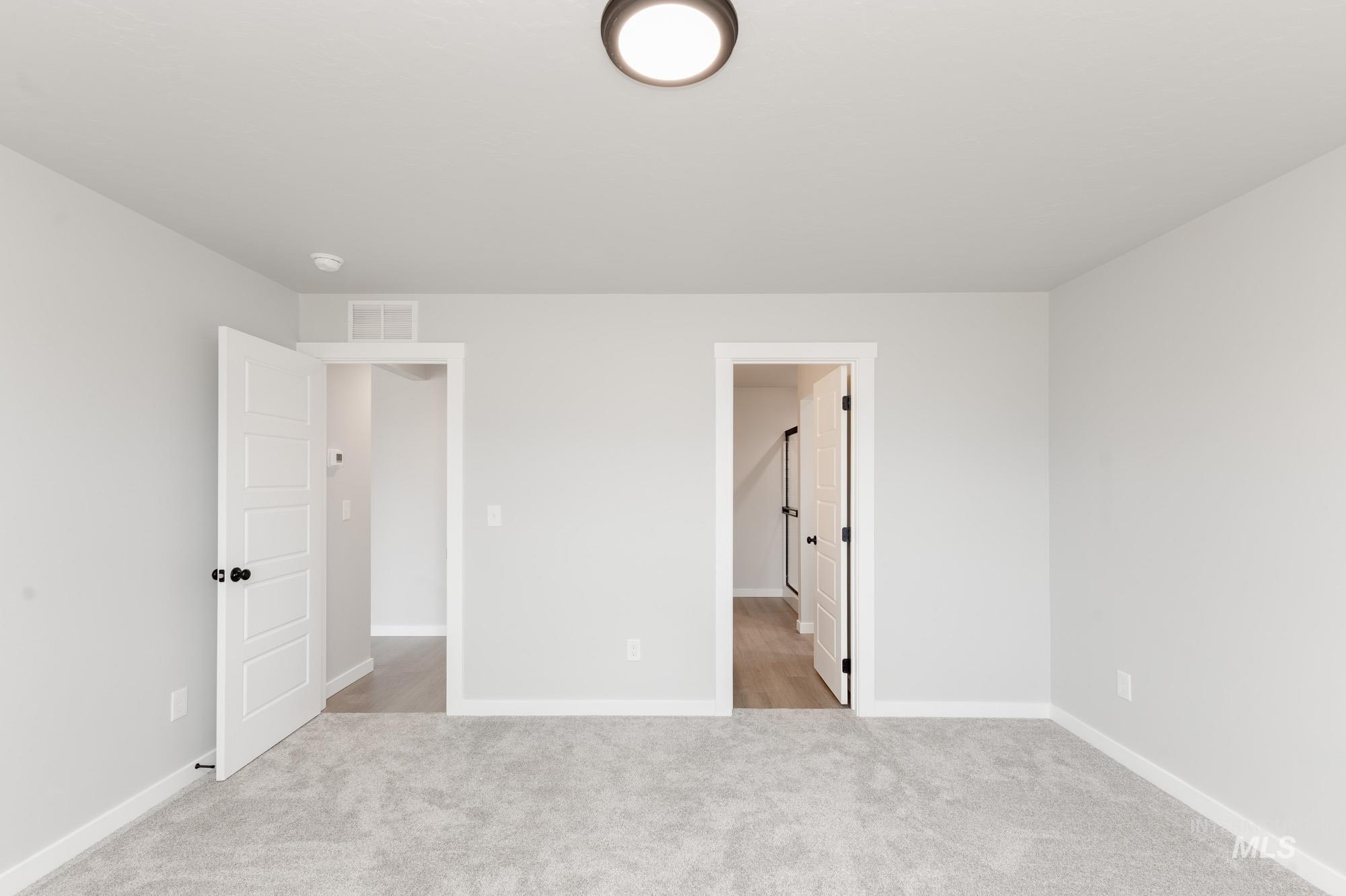 Unfurnished bedroom featuring baseboards and light colored carpet