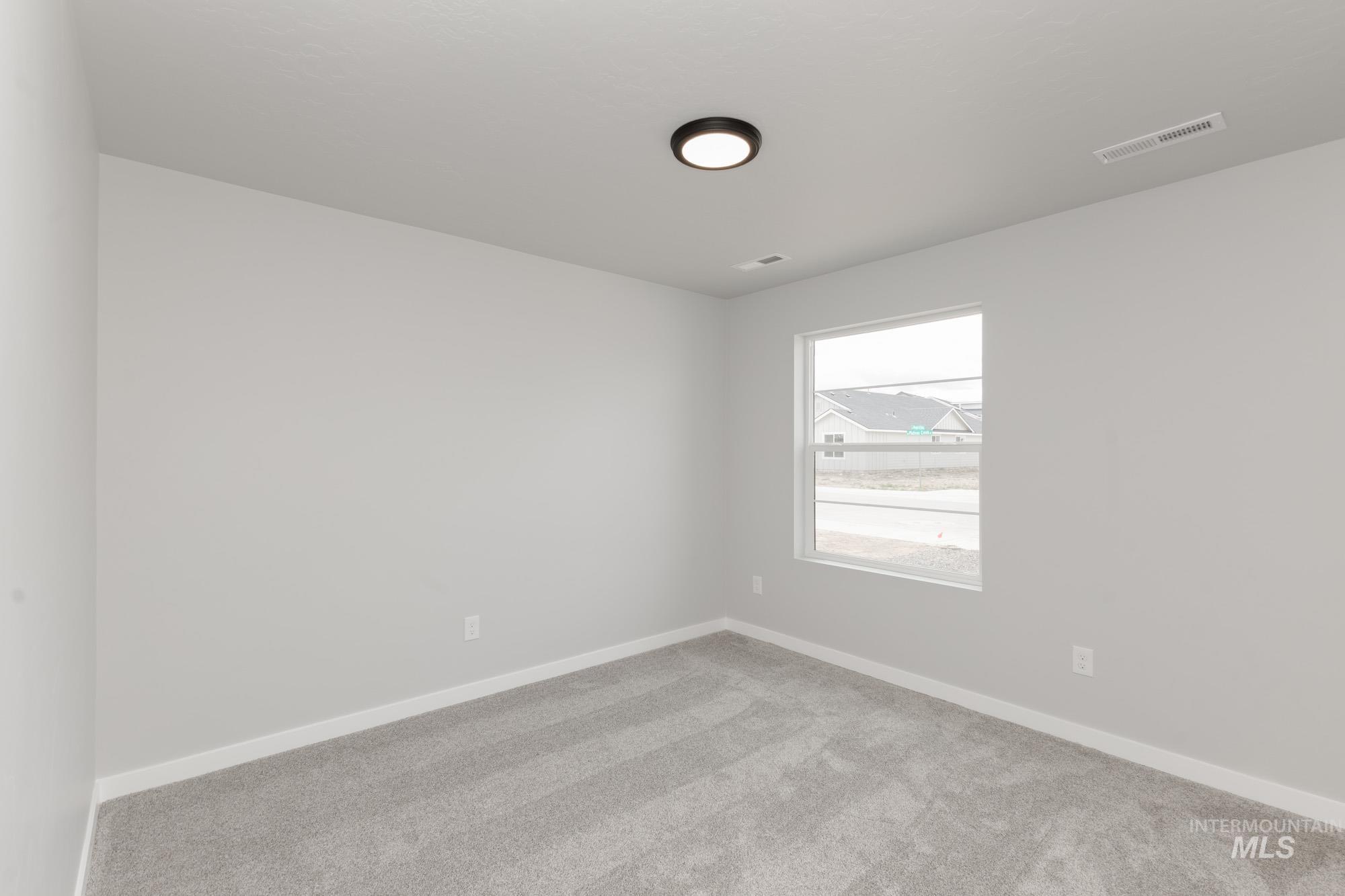 Carpeted empty room featuring baseboards