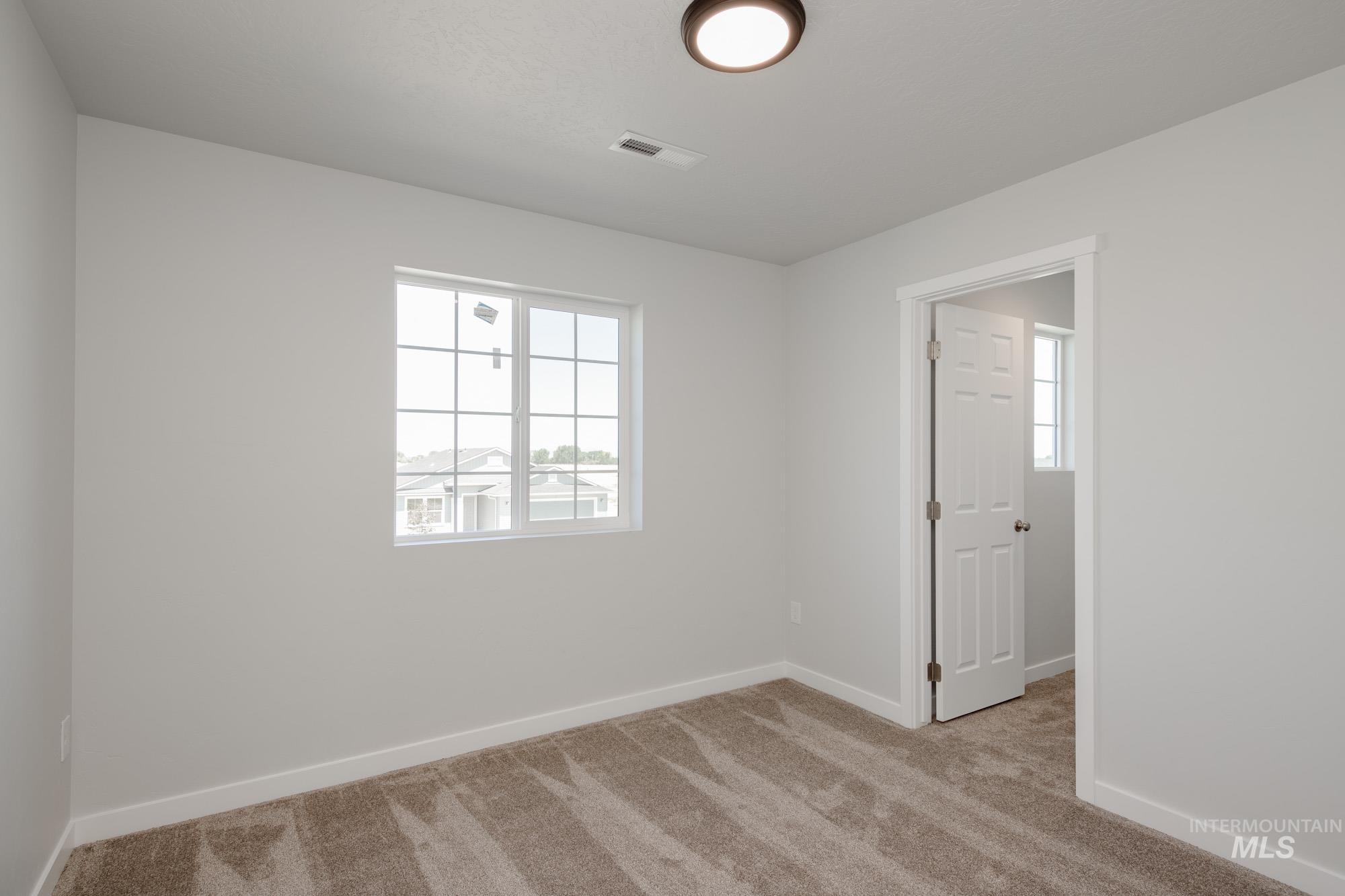 Carpeted empty room featuring baseboards