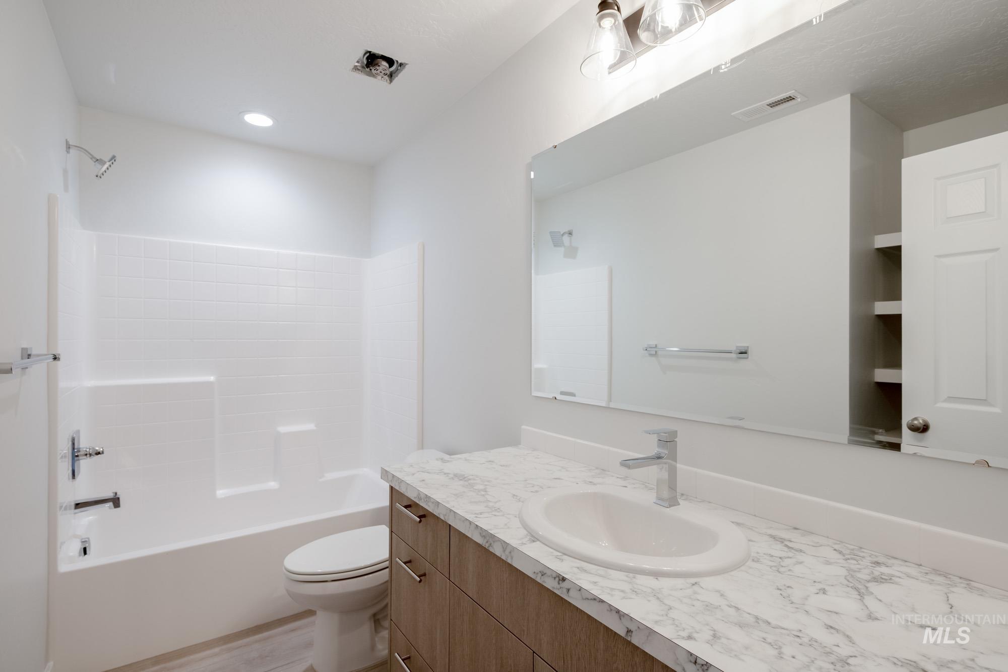 Bathroom with vanity, shower / washtub combination, and wood finished floors