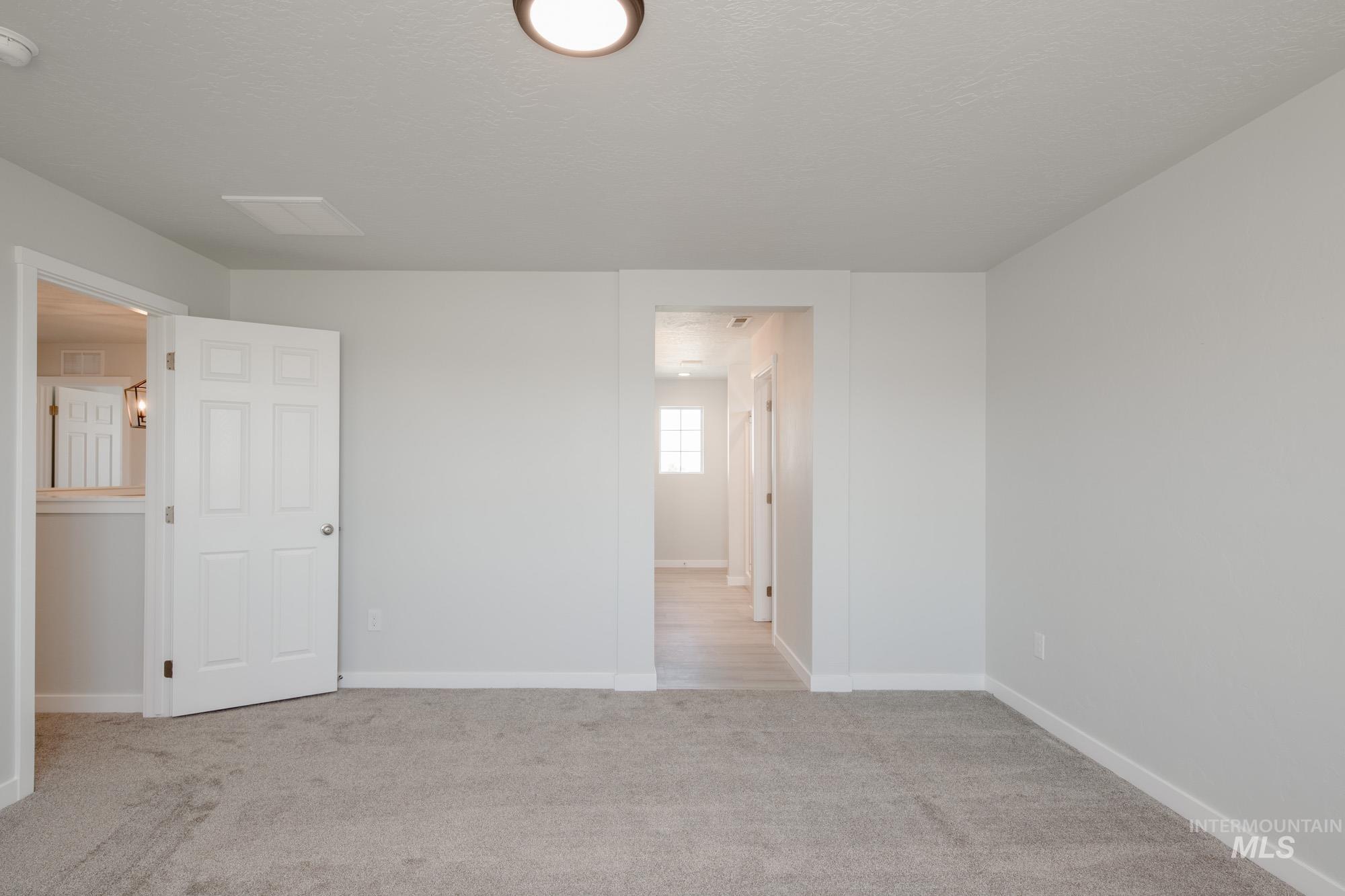 Empty room with carpet and baseboards