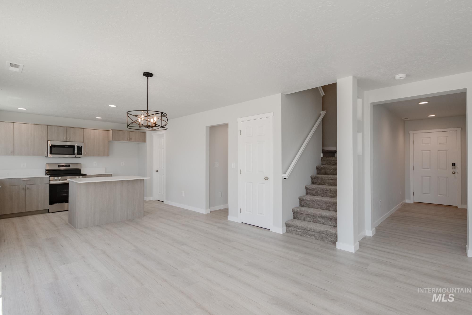 Kitchen featuring recessed lighting, modern cabinets, light wood-type flooring, stainless steel appliances, and light countertops