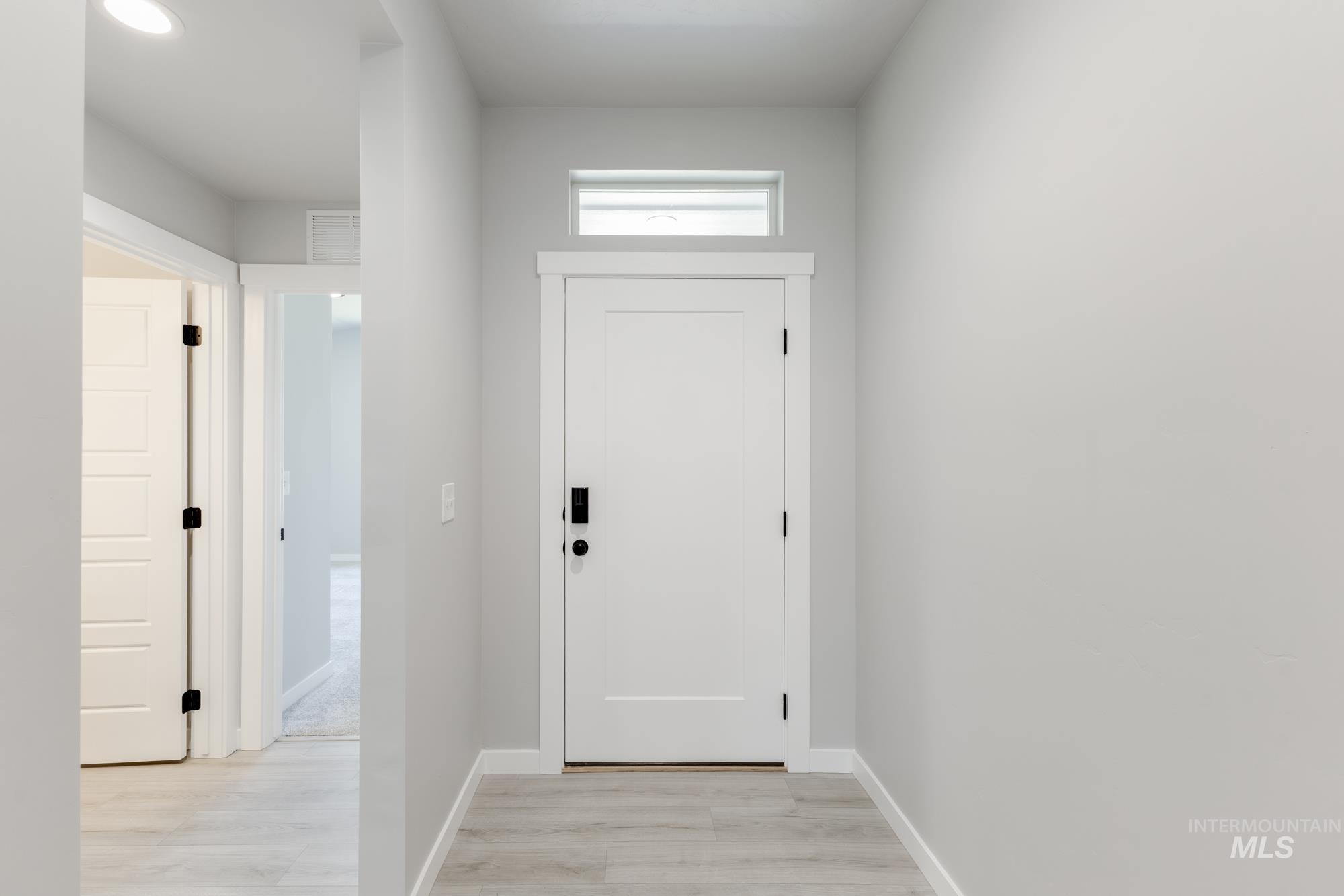 Doorway with light wood-style floors