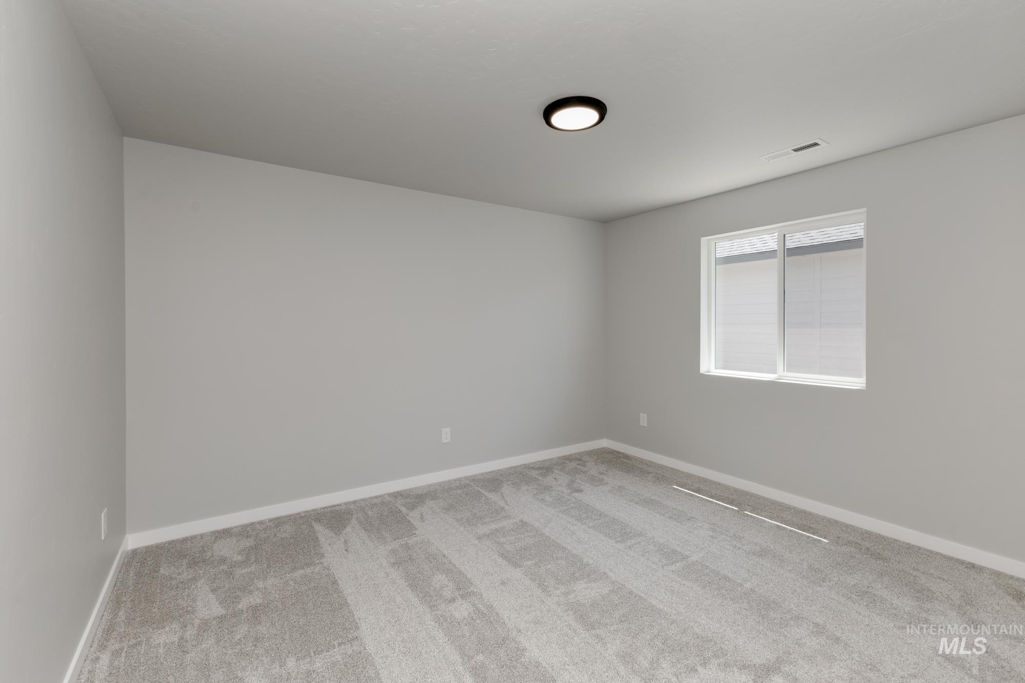 Carpeted empty room with baseboards