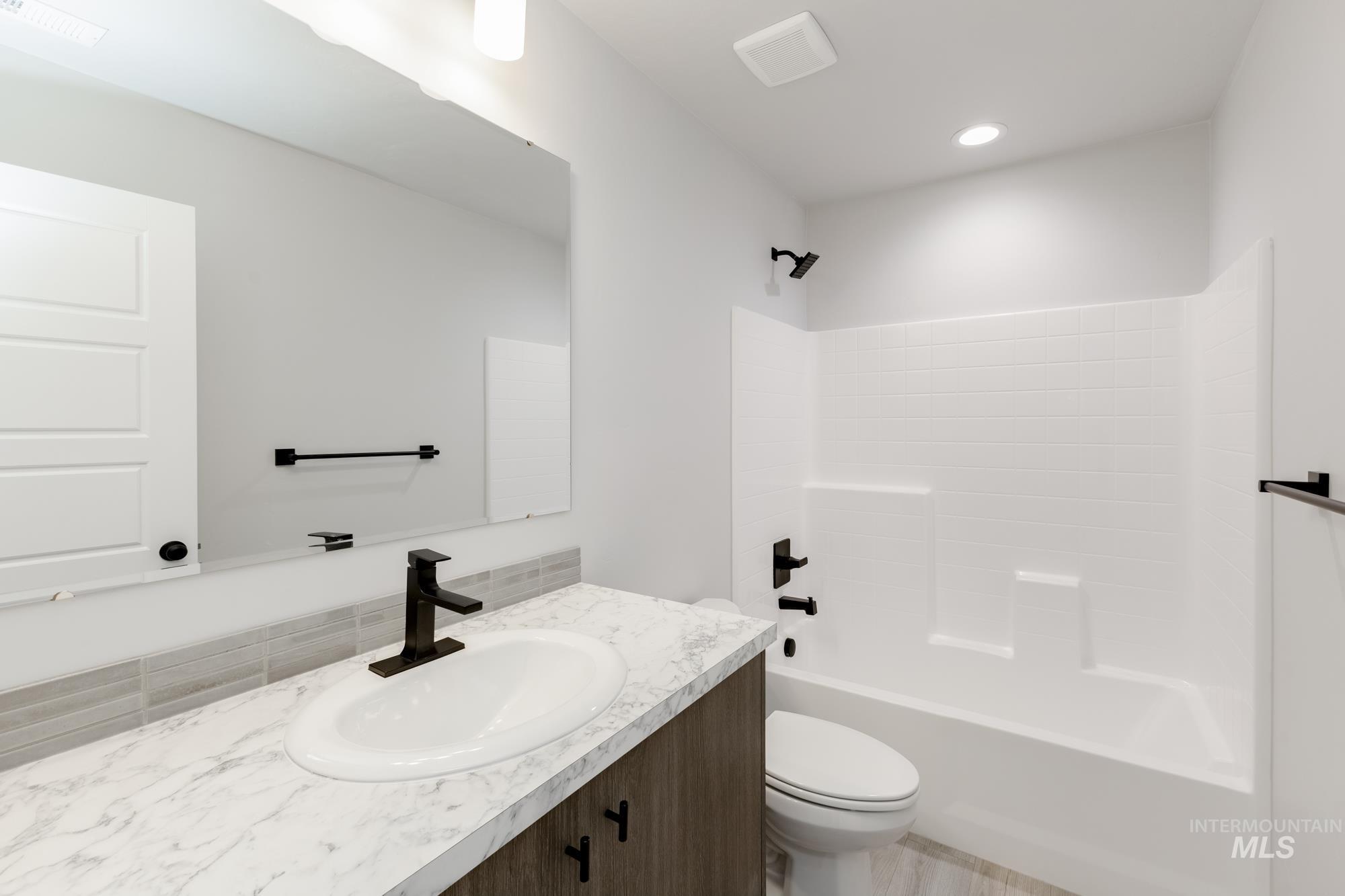 Full bathroom with vanity, shower / bathtub combination, and recessed lighting