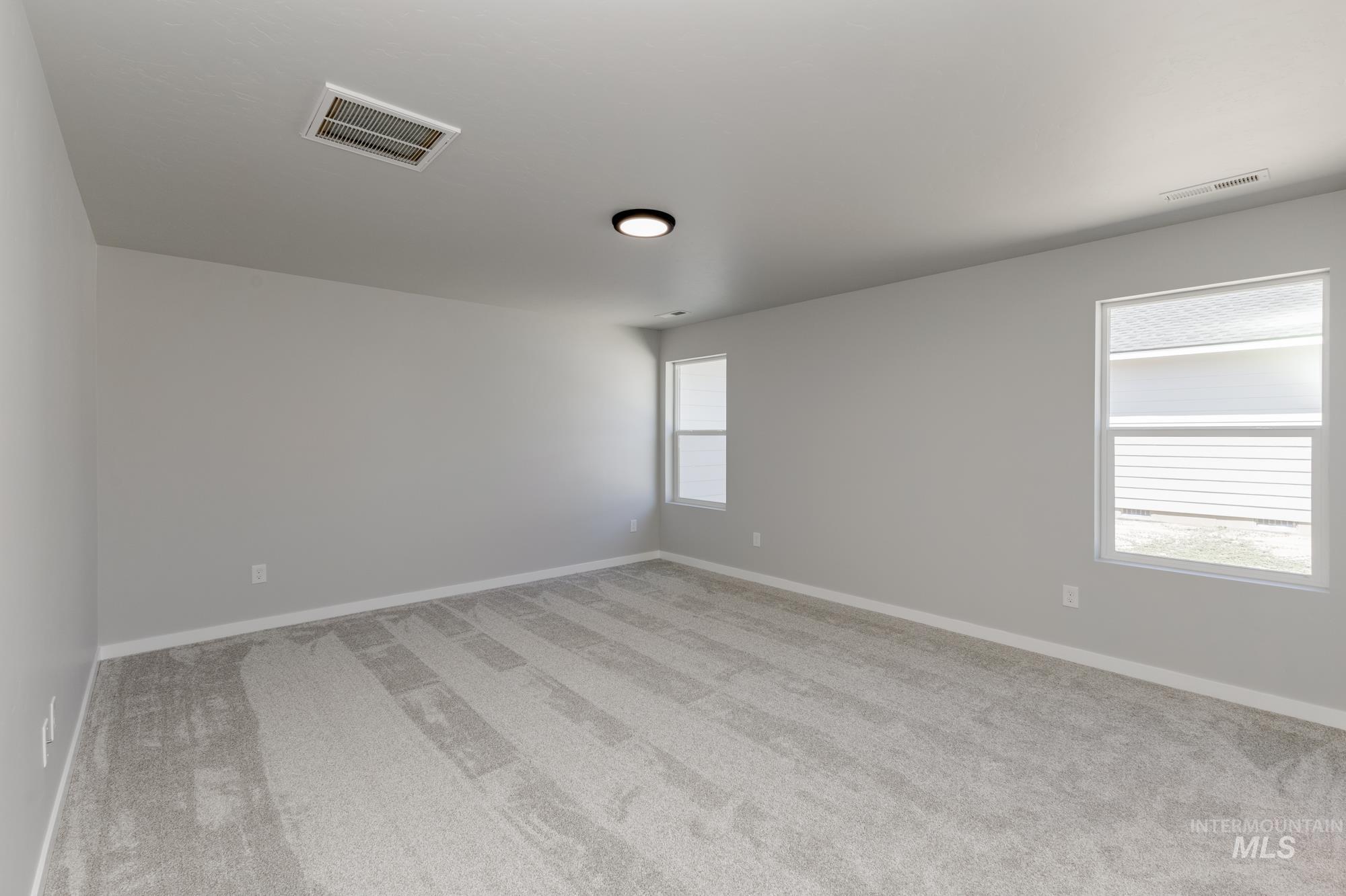 Unfurnished room featuring light carpet