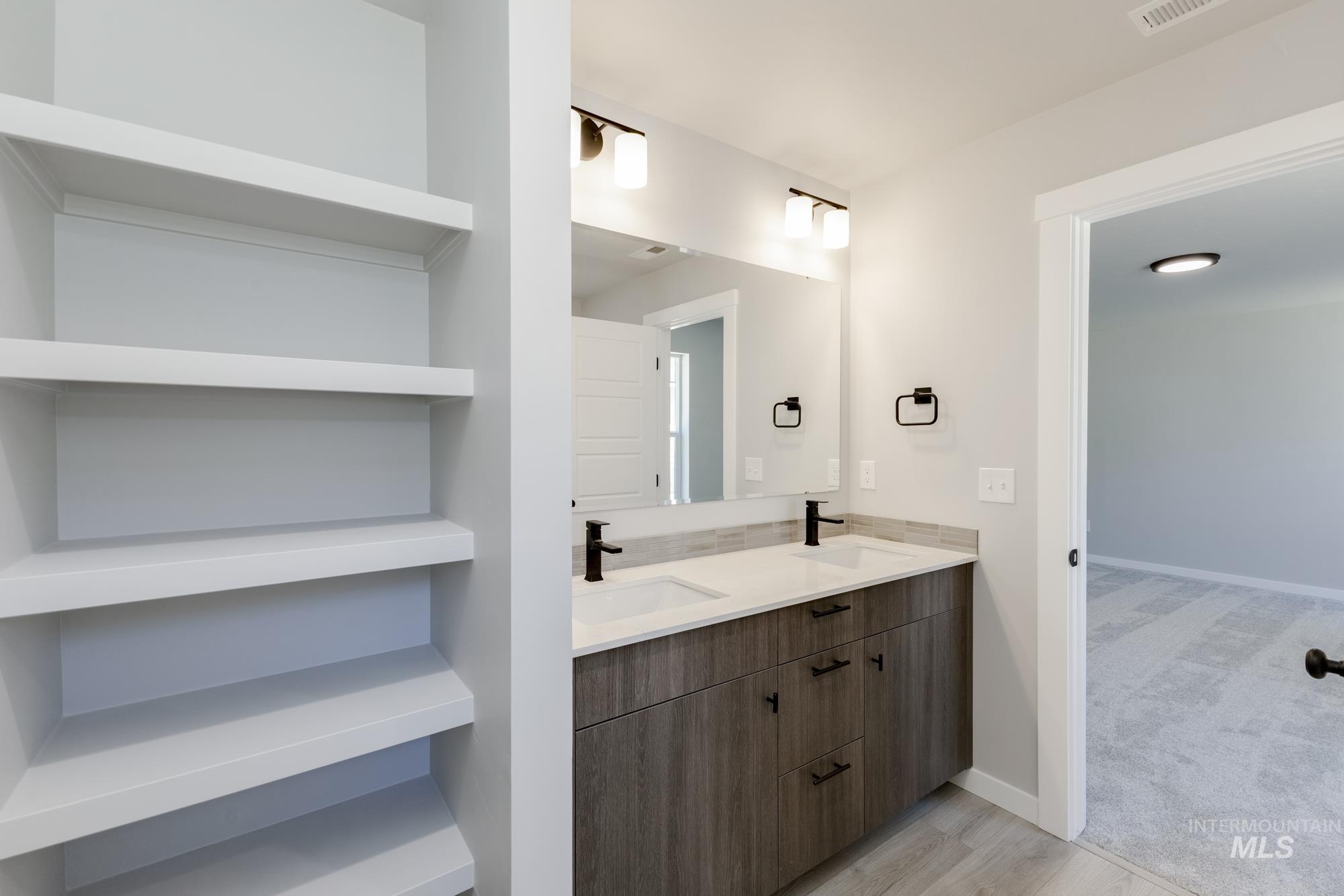 Bathroom featuring double vanity and wood finished floors