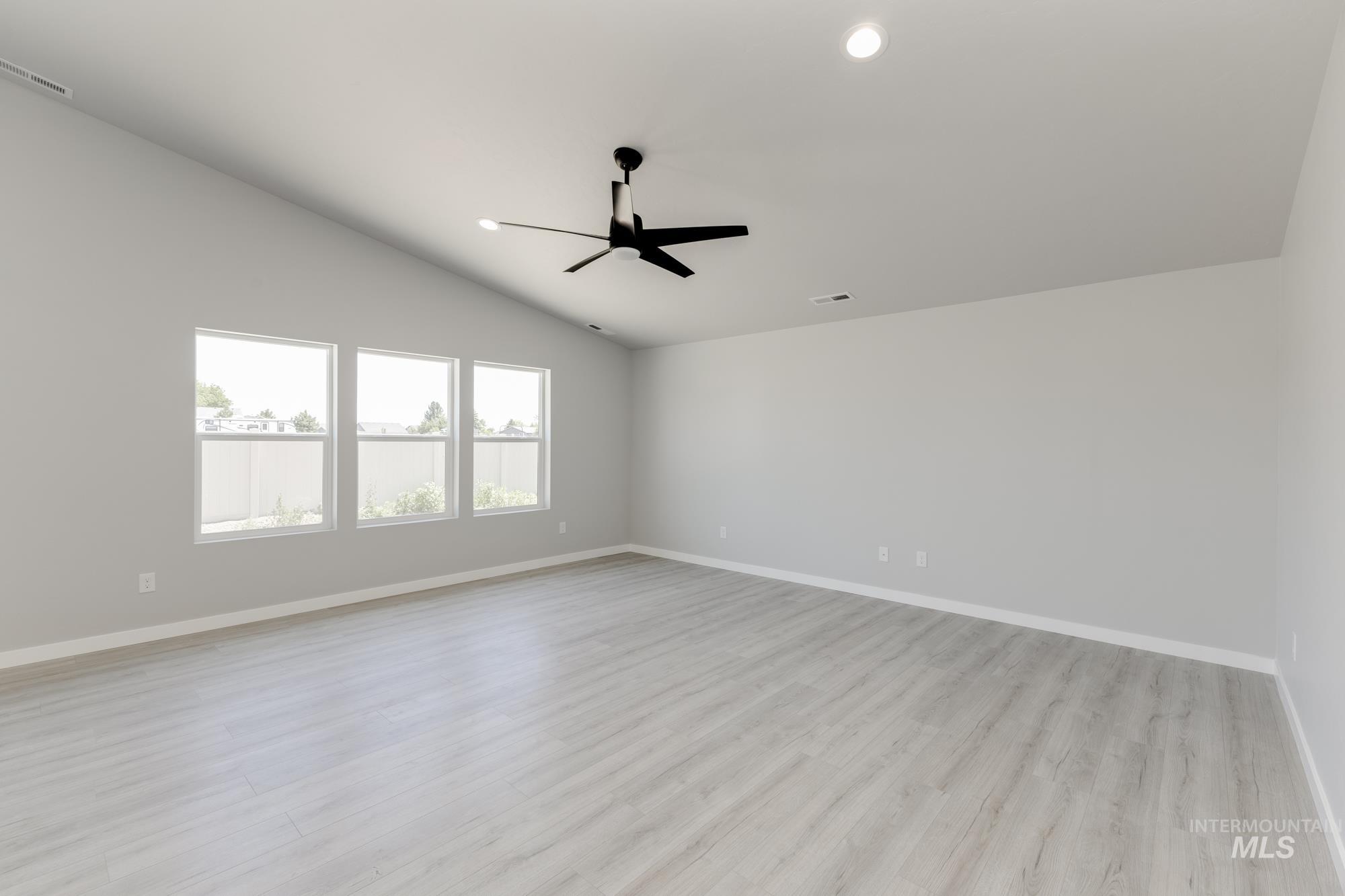 Spare room featuring lofted ceiling, light wood-style floors, ceiling fan, and recessed lighting