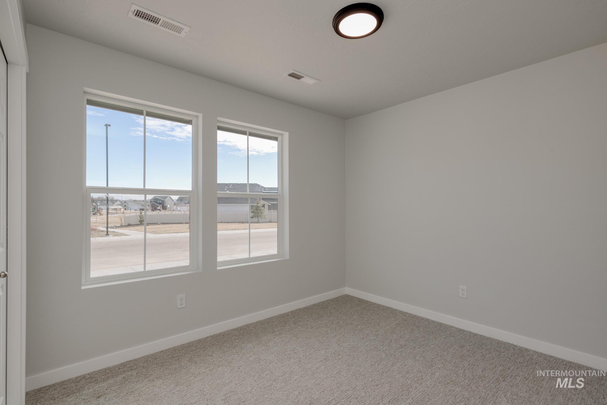 Spare room featuring baseboards and carpet floors