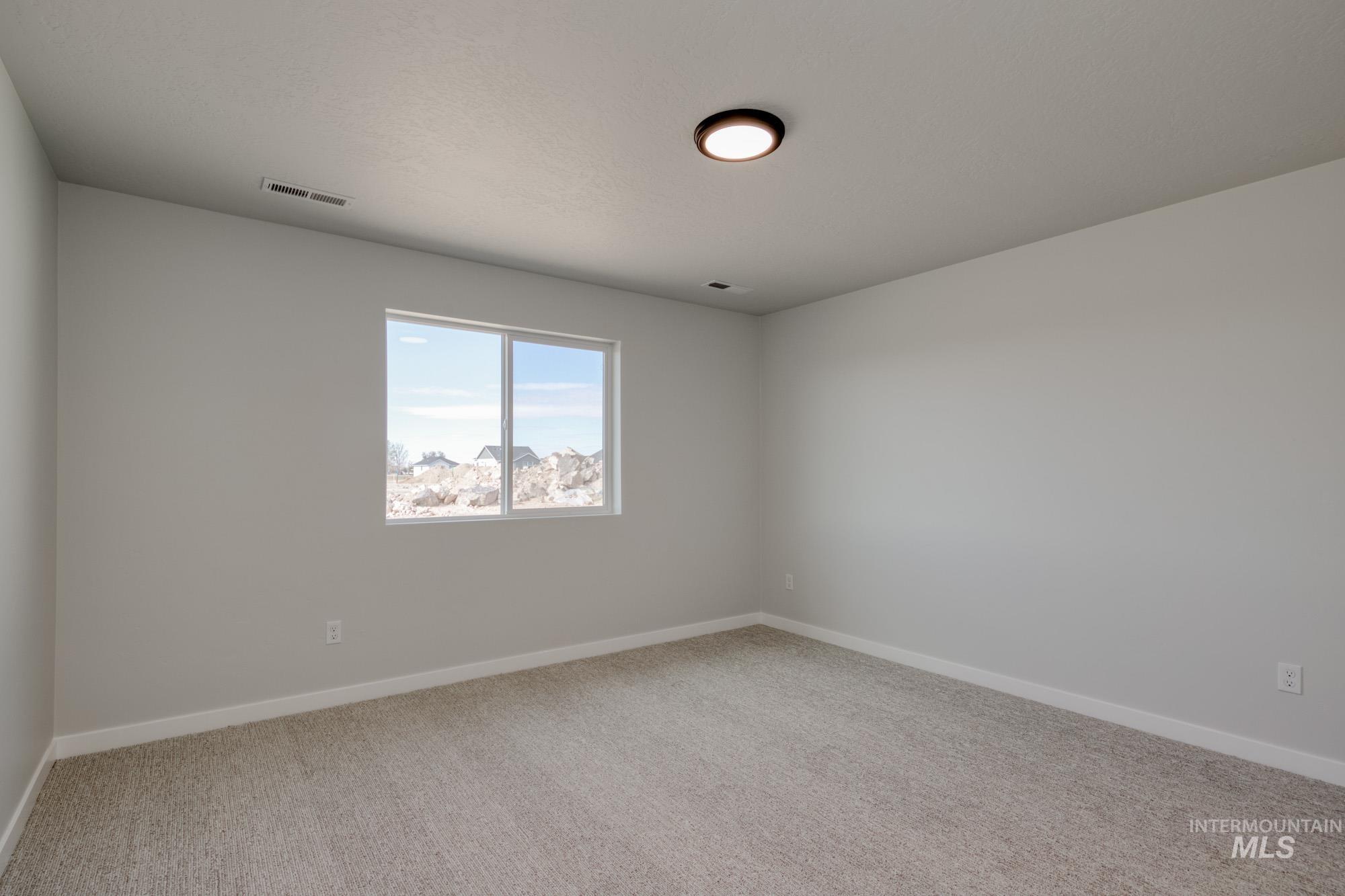 Spare room featuring baseboards and light carpet