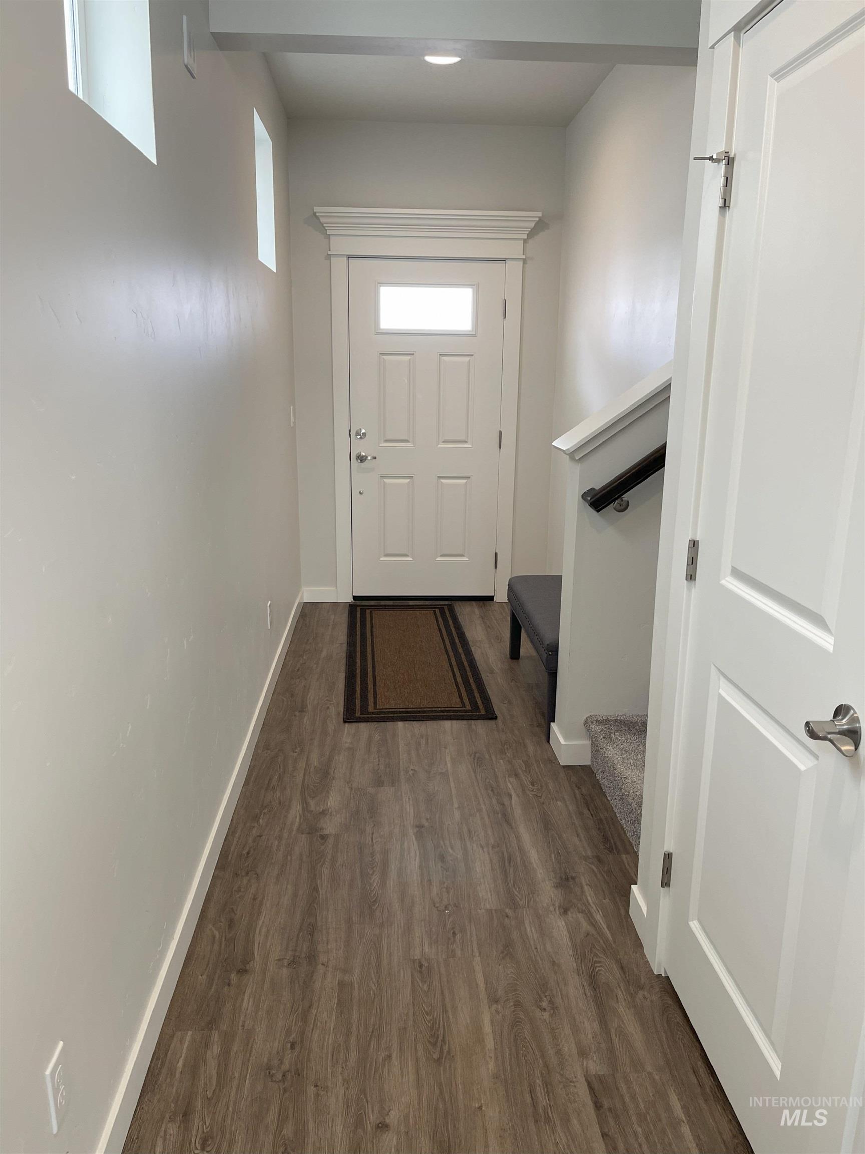 Doorway featuring stairs and wood finished floors