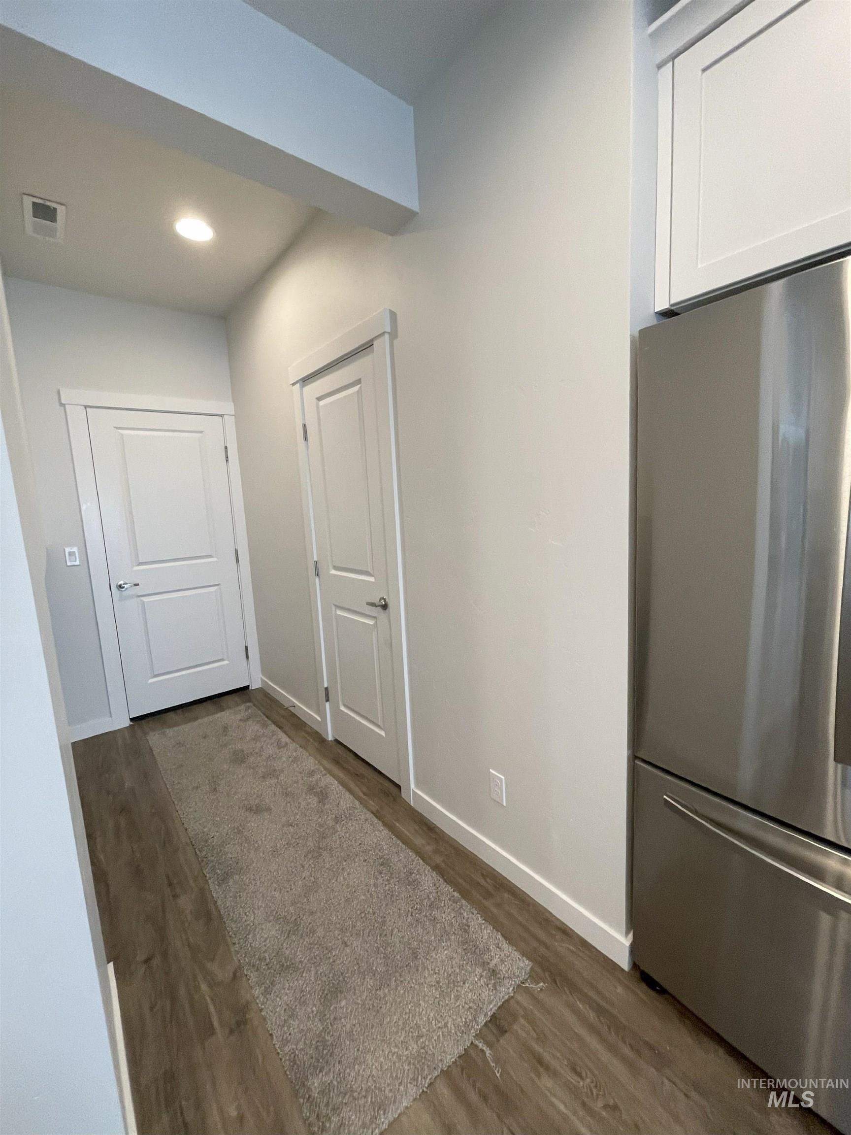 Kitchen featuring freestanding refrigerator, dark wood-style flooring, recessed lighting, and white cabinetry
