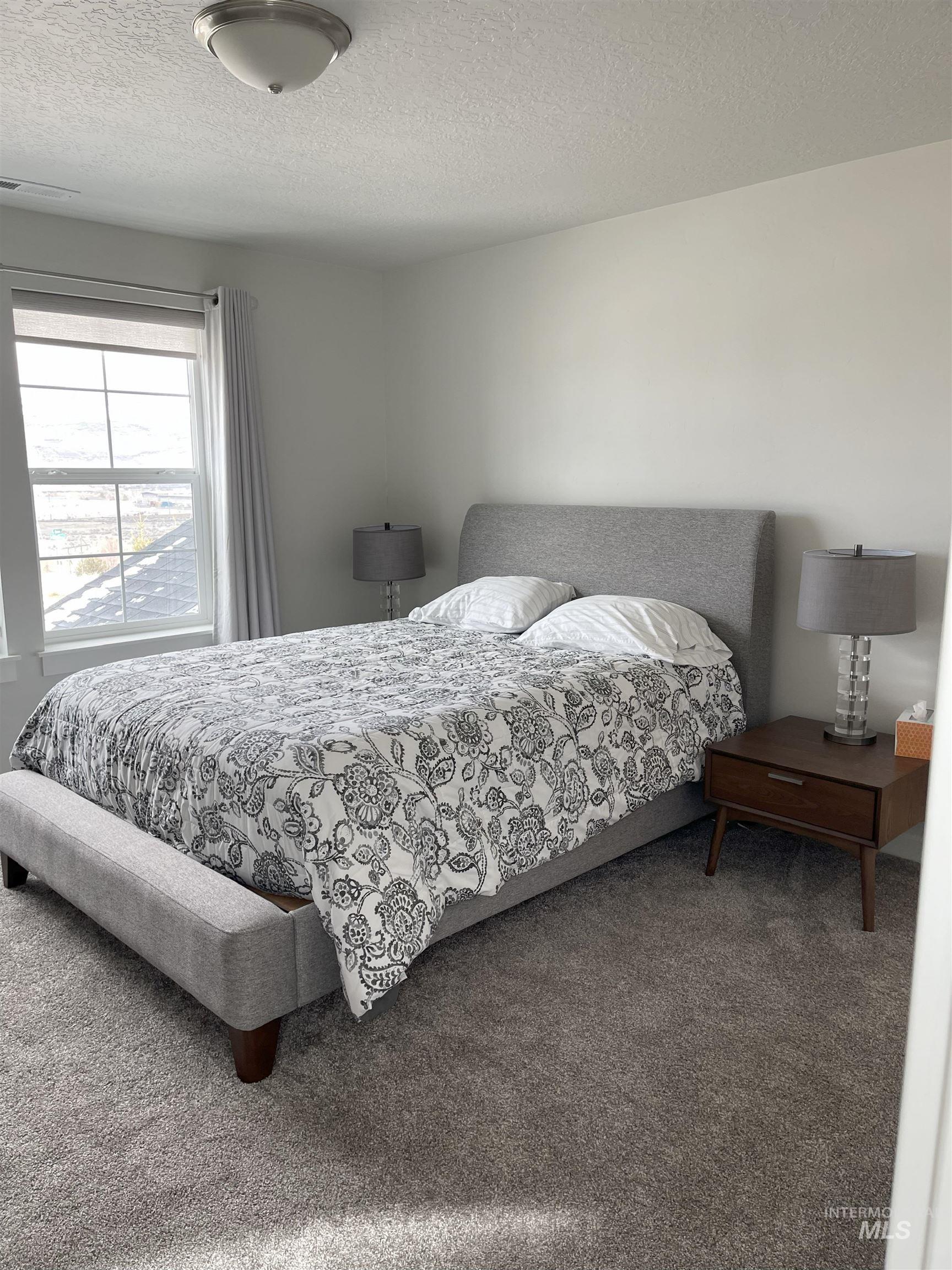 Carpeted bedroom featuring a textured ceiling