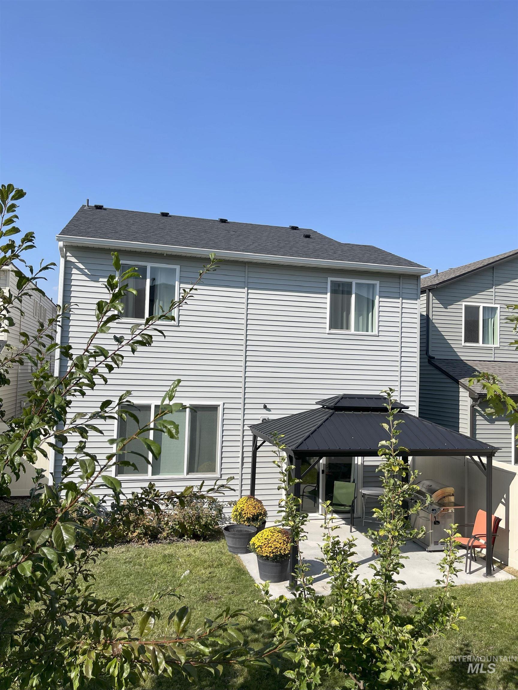 Back of house with a gazebo, a patio, and a yard