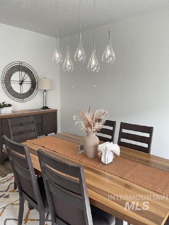 Dining space featuring a textured ceiling and light wood-type flooring