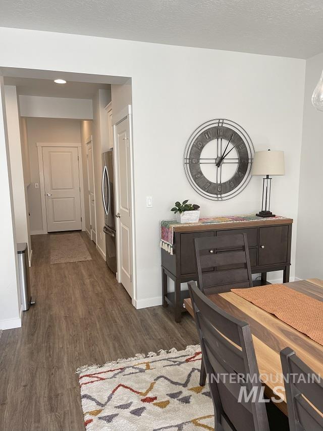 Dining room featuring dark wood-style flooring and a textured ceiling