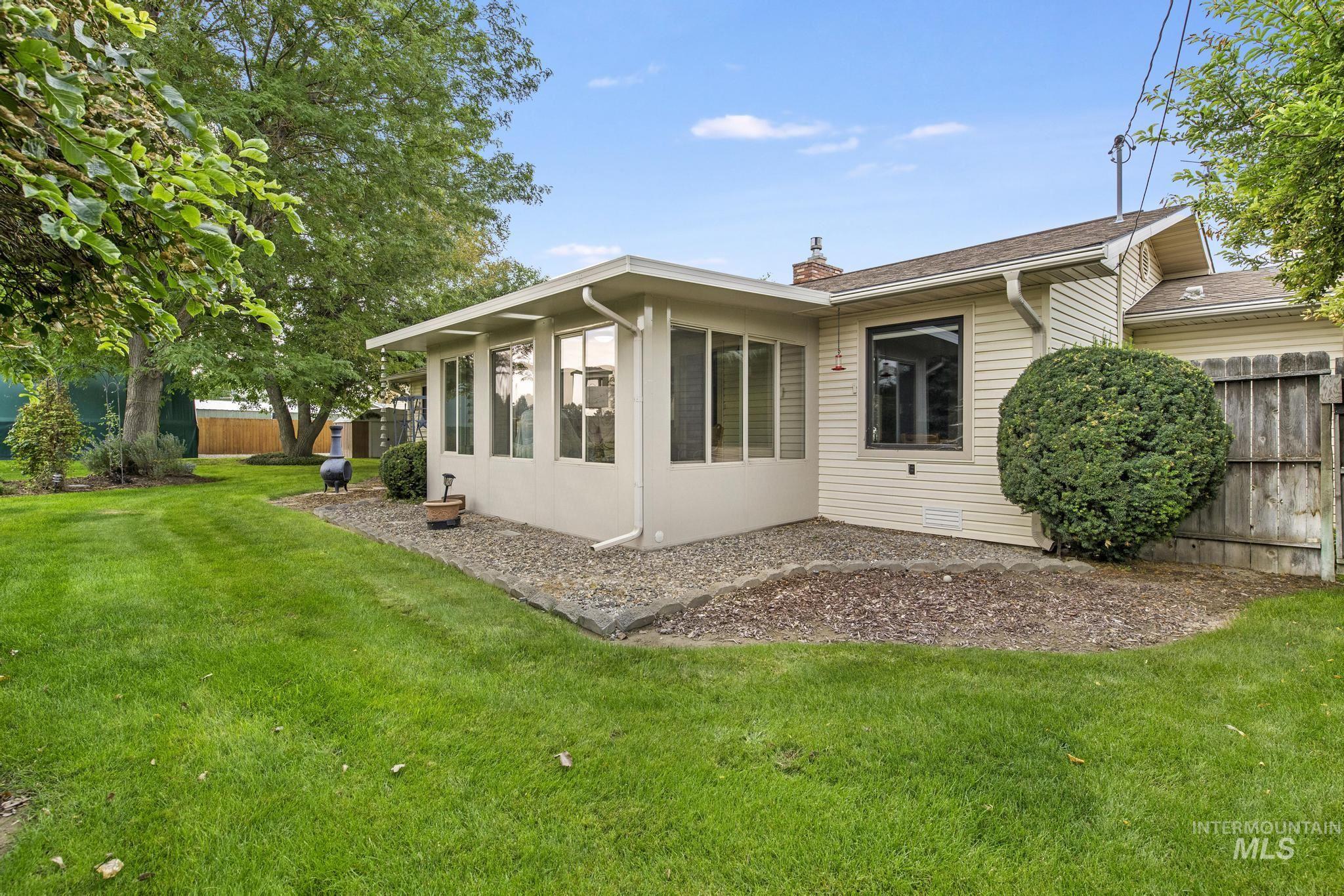 Rear view of house with a sunroom and a chimney