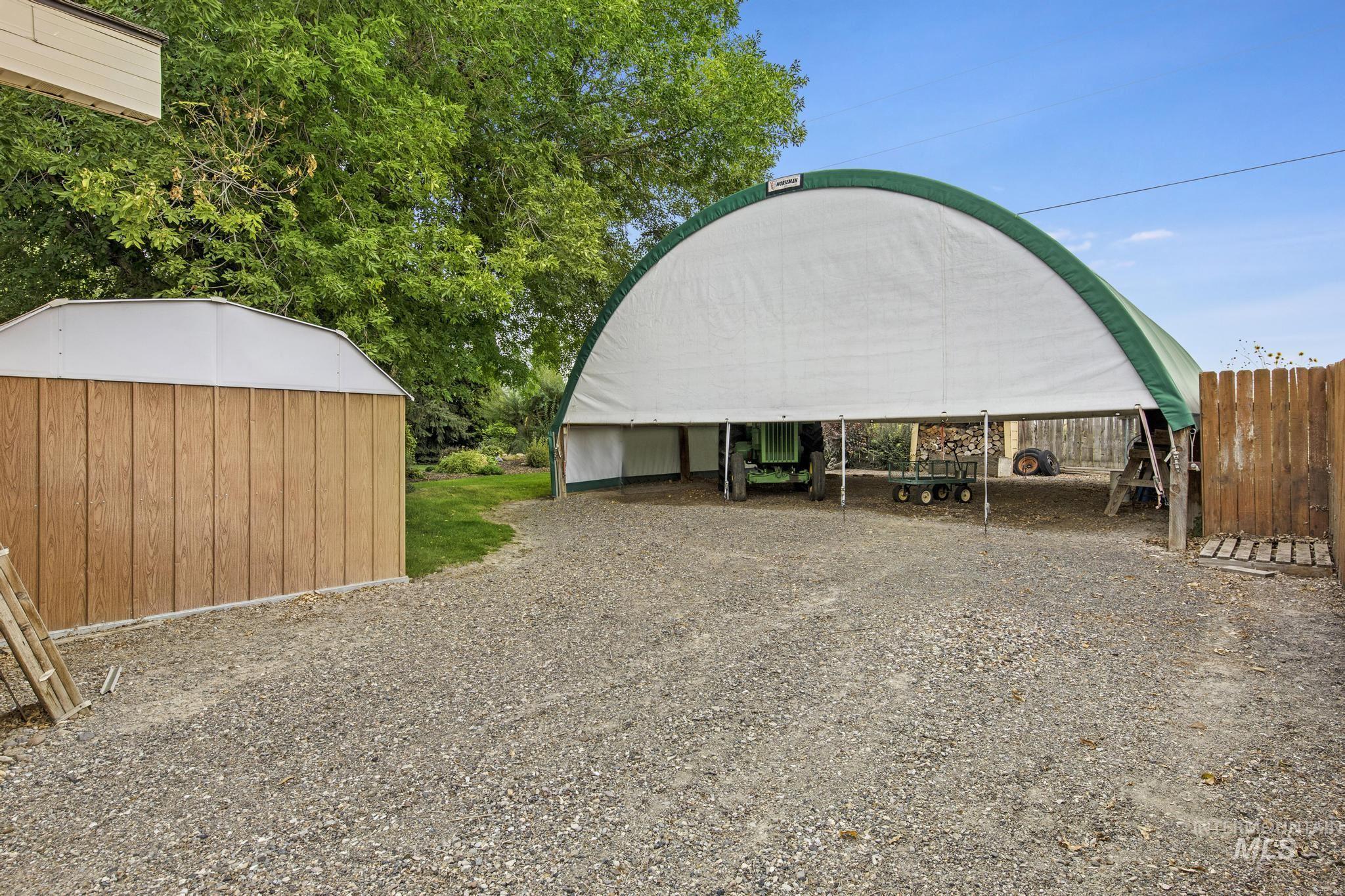 View of outbuilding featuring a carport and driveway
