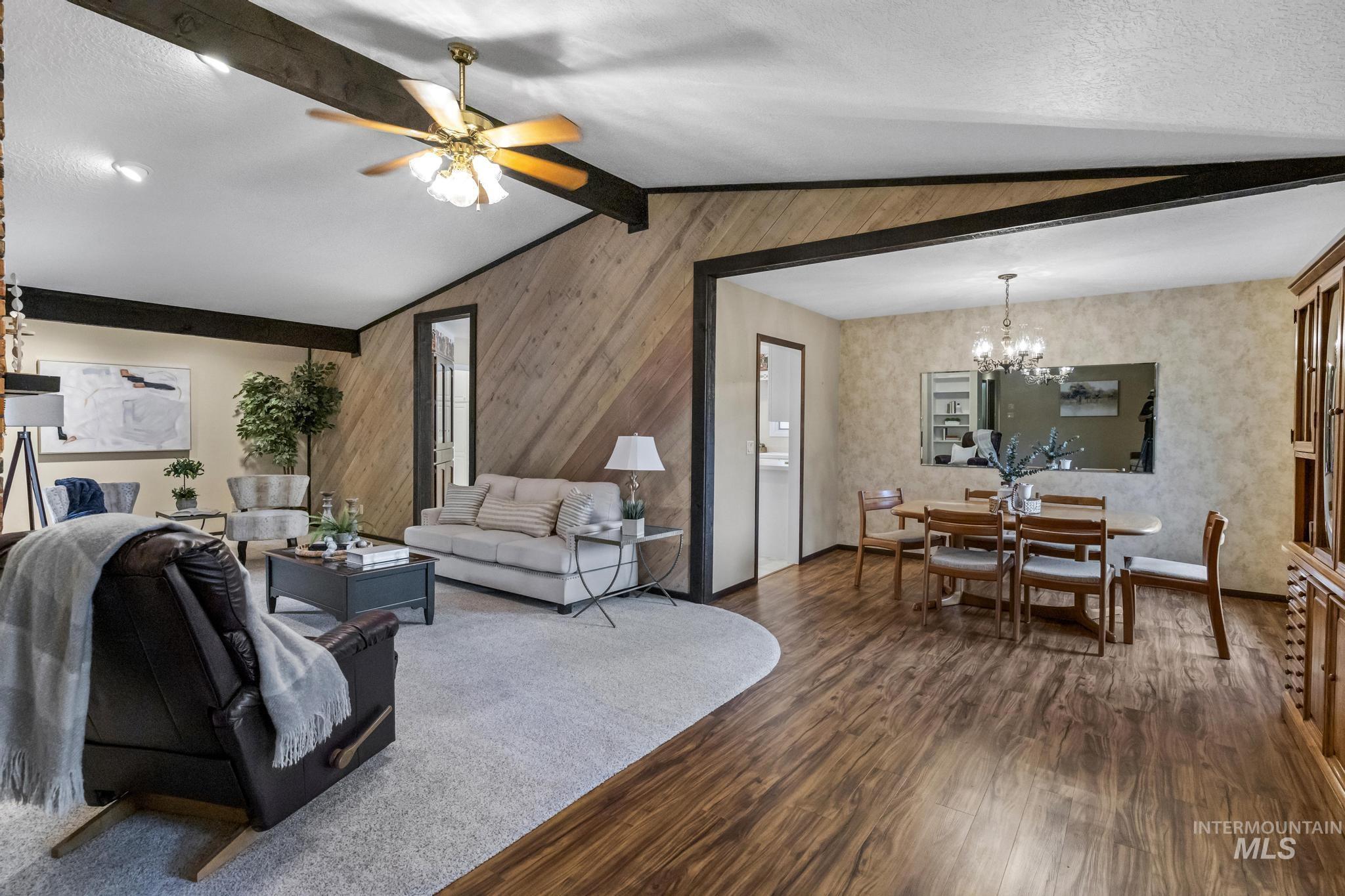 Living area with a chandelier, wood finished floors, and ceiling fan