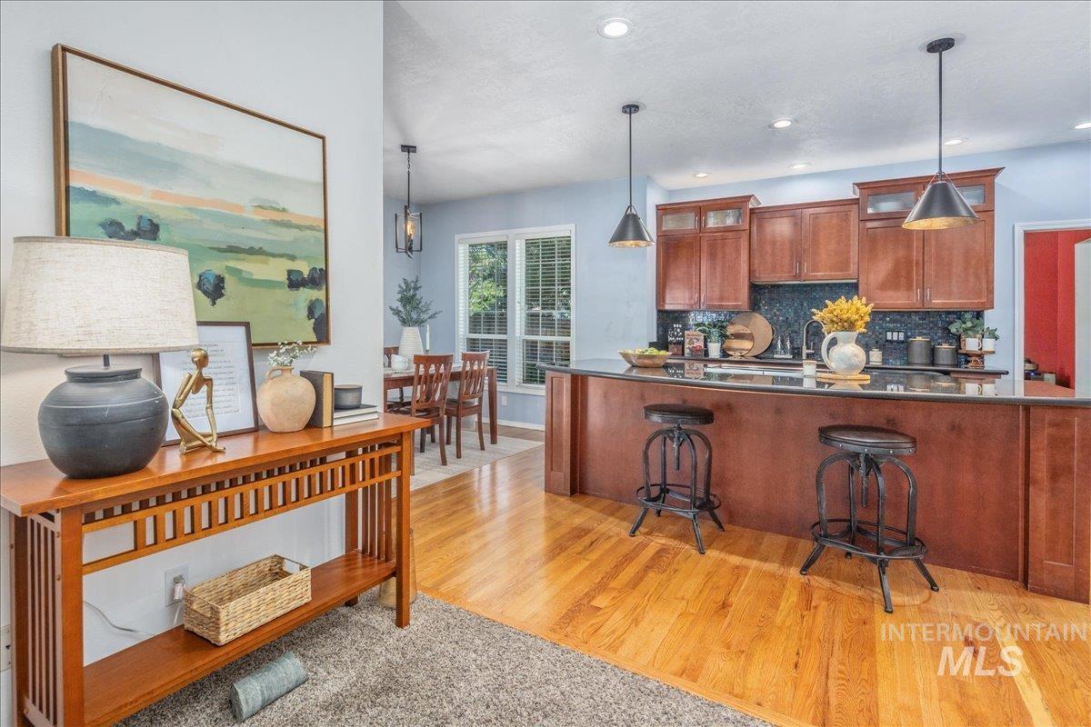 Kitchen with light wood-style floors, dark countertops, pendant lighting, and recessed lighting