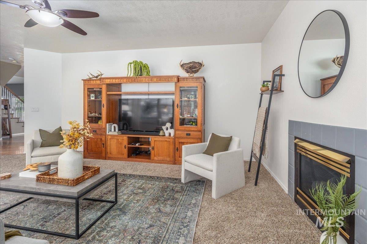 Living room with a ceiling fan and a tiled fireplace