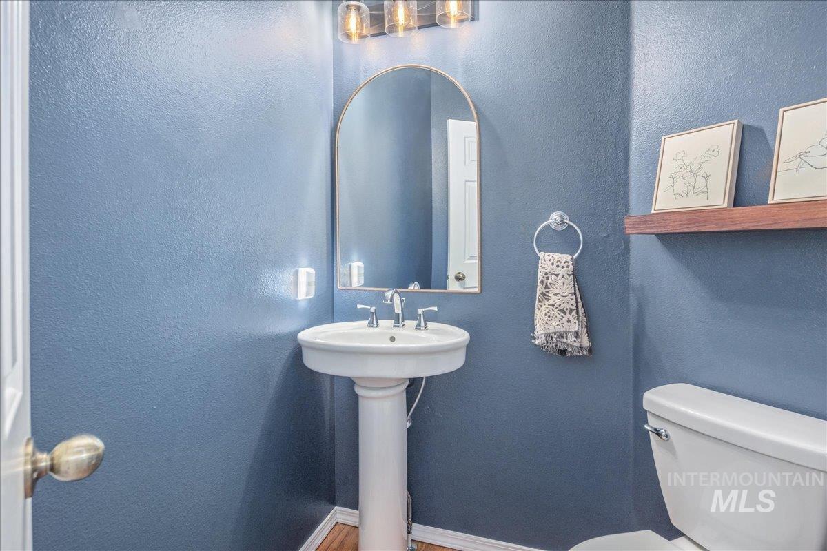 Half bath with toilet and wood finished floors