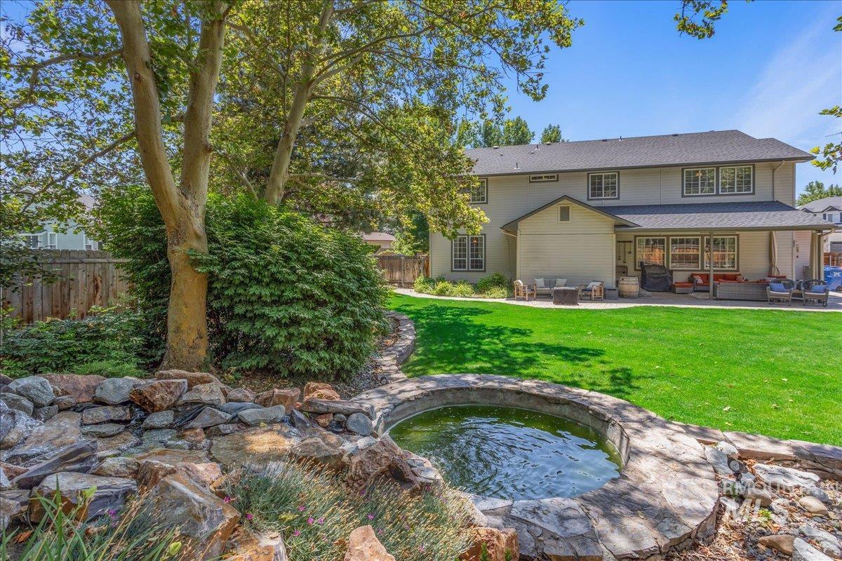 Back of property with outdoor lounge area, a fenced backyard, a patio area, a water feature