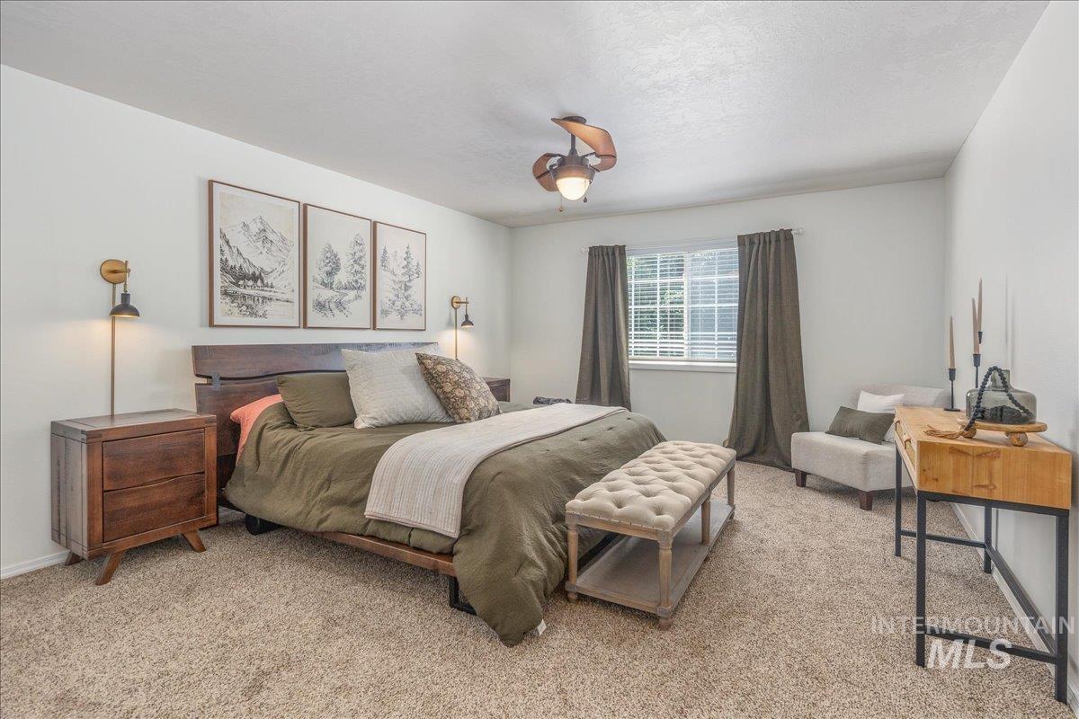 Bedroom with light colored carpet and ceiling fan