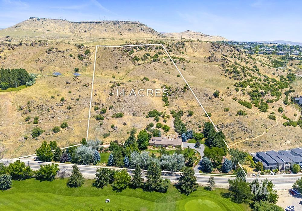 Aerial view of property and surrounding area featuring a mountain backdrop and property parcel outlined