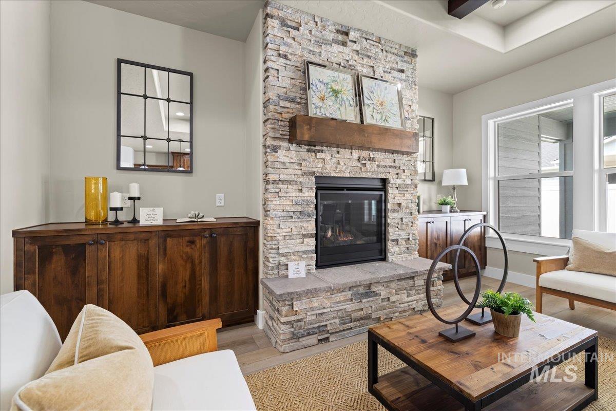 Living room featuring wood finished floors and a stone fireplace
