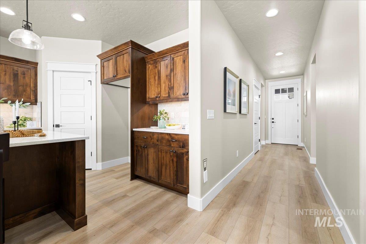 Corridor featuring a textured ceiling, recessed lighting, and light wood-style floors