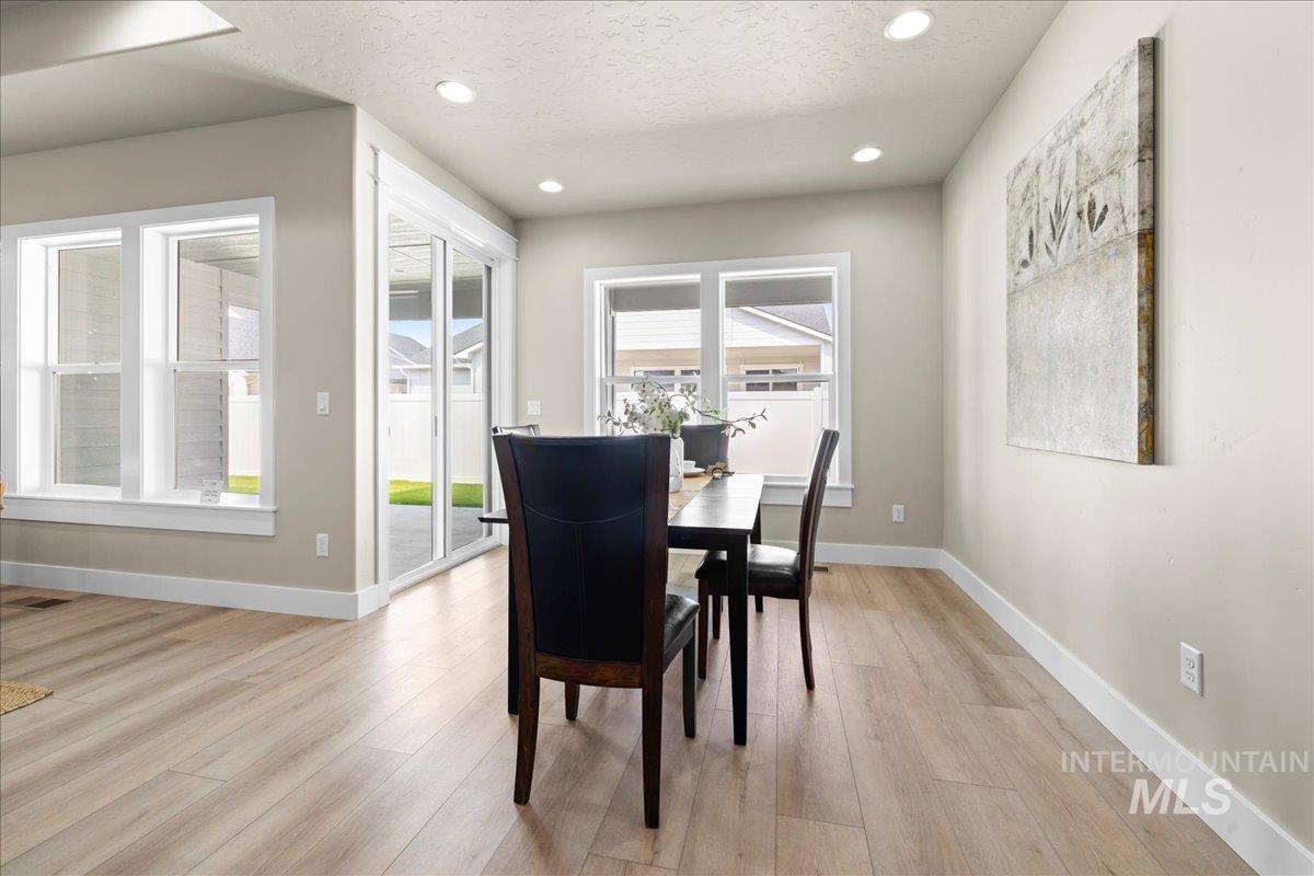 Dining room featuring light wood-style flooring, recessed lighting, and a textured ceiling