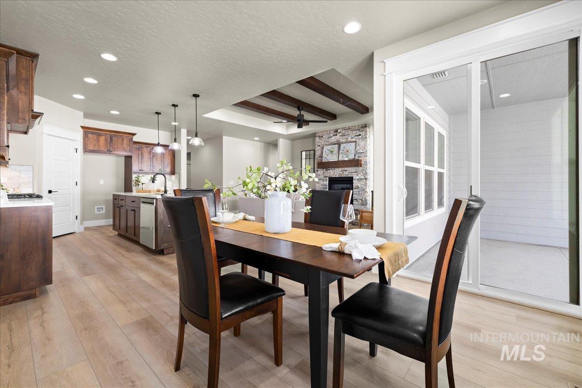 Dining room featuring light wood-type flooring, beamed ceiling, a textured ceiling, ceiling fan, and recessed lighting
